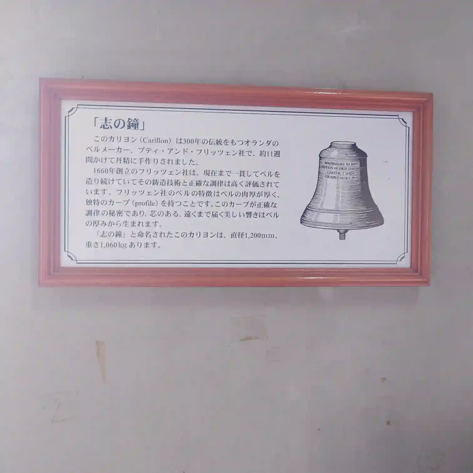 志の鐘の解説パネル alt: 中伊豆ワイナリーにある「志の鐘」の歴史と特徴を説明した案内板