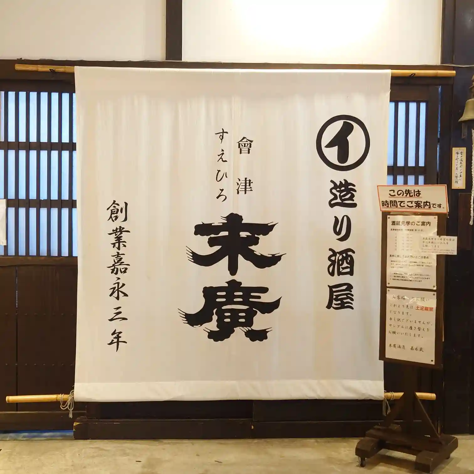 末廣酒造の館内に掲げられた白い暖簾とロゴ