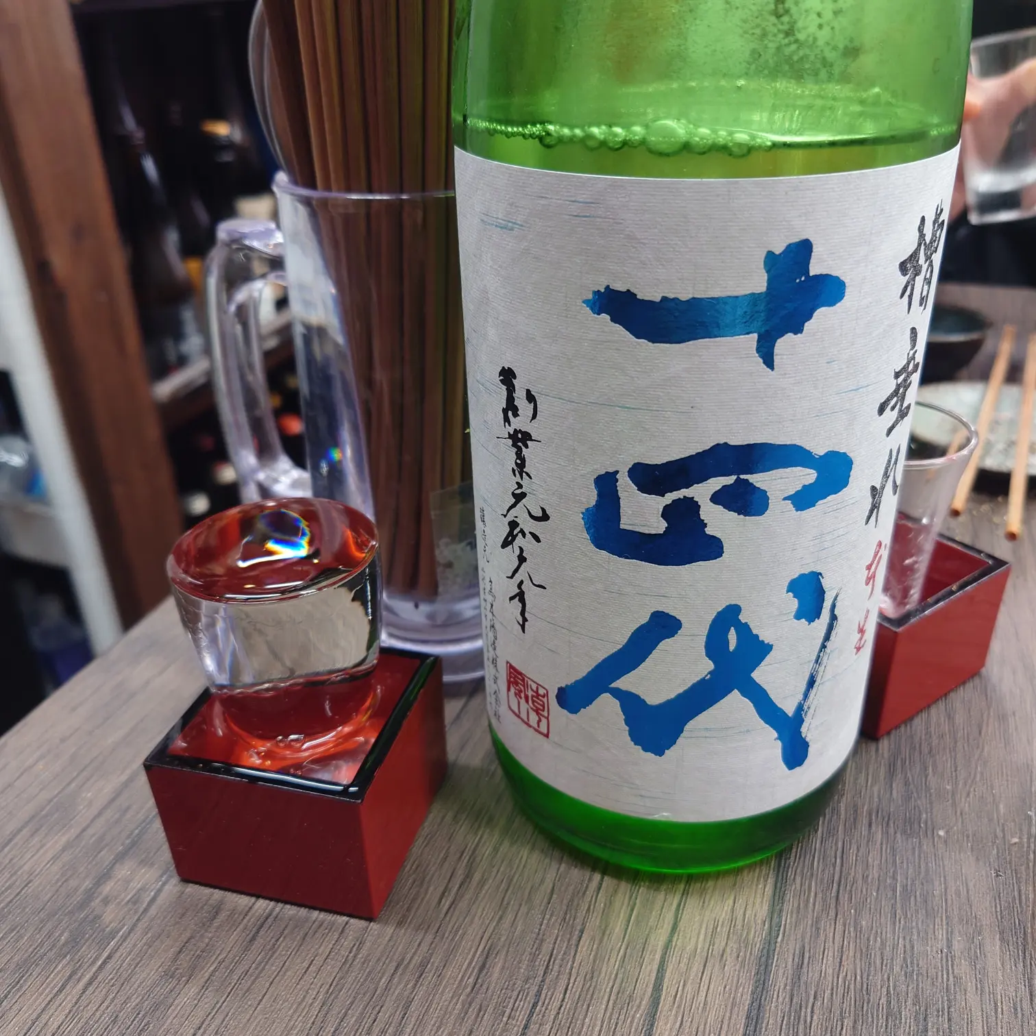 十四代 槽垂れ 本生 純米吟醸のボトルと枡こぼしのグラス|熱海ミニ横丁(伊豆半島合同会社)での提供シーン