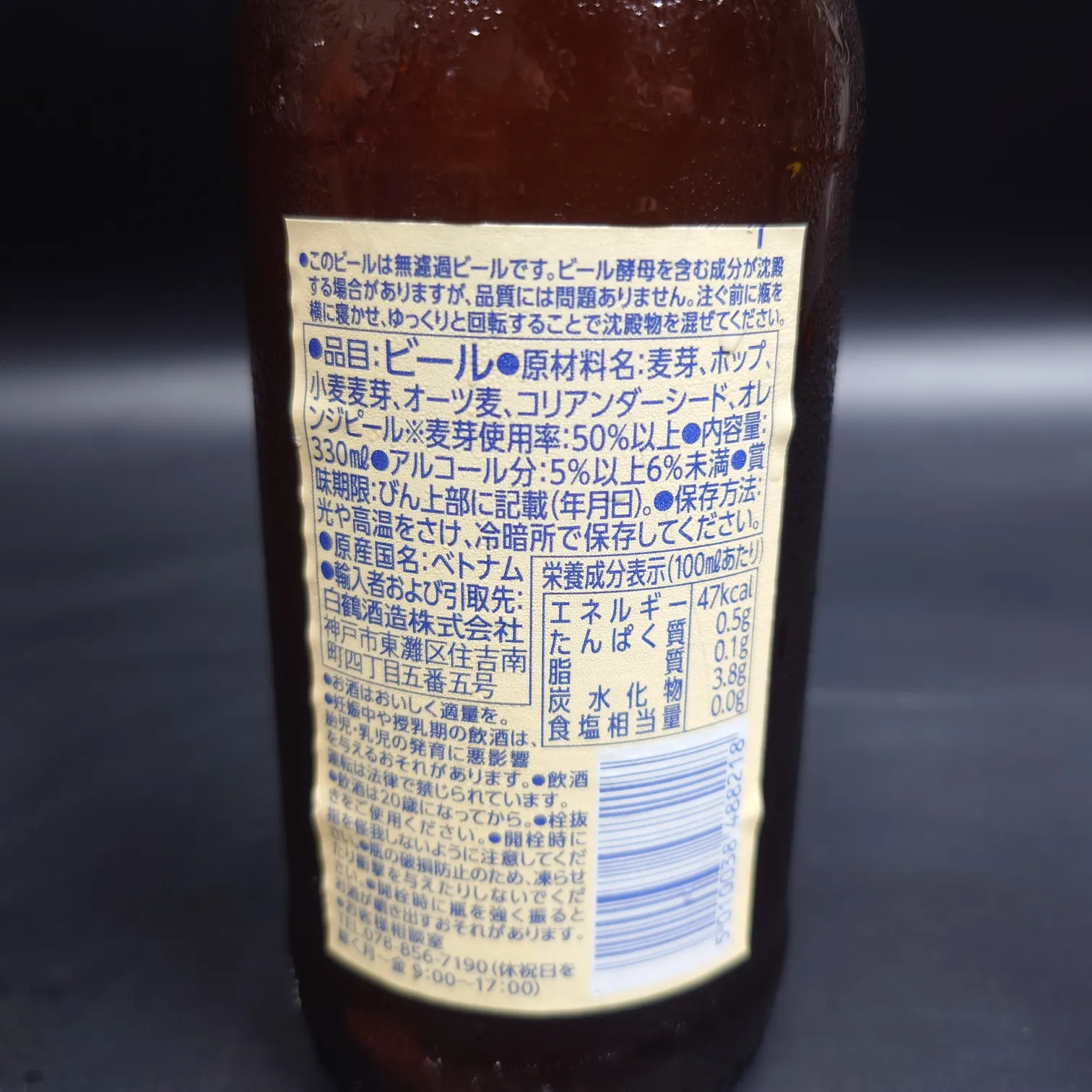 ブルームーン ベルジャンホワイト 裏ラベルの近接写真 原材料と栄養成分表示 結露した茶色ボトル 黒背景