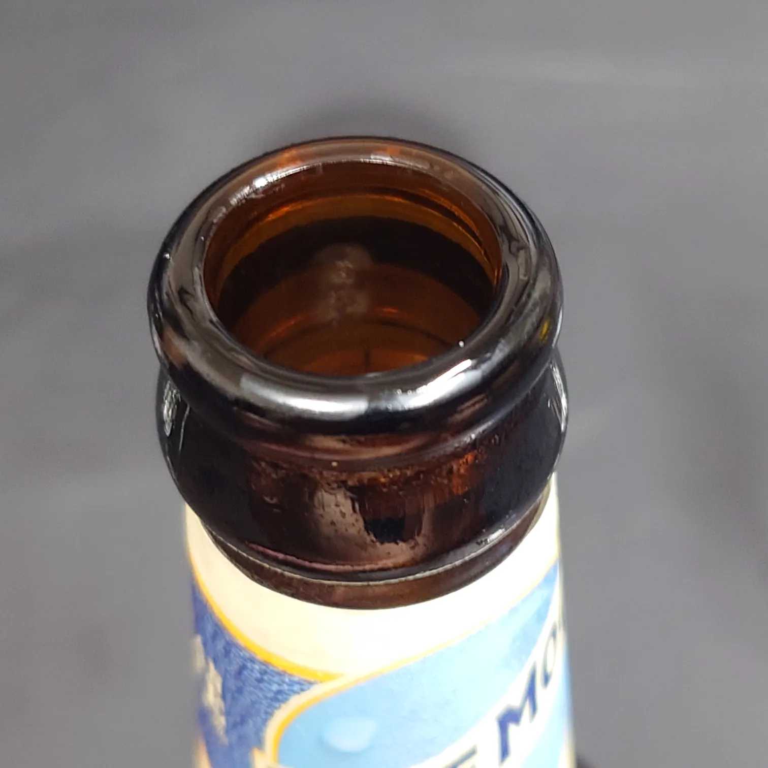 ブルームーン ベルジャンホワイト ボトルの飲み口アップ 茶色ガラスの口部に結露 黒背景