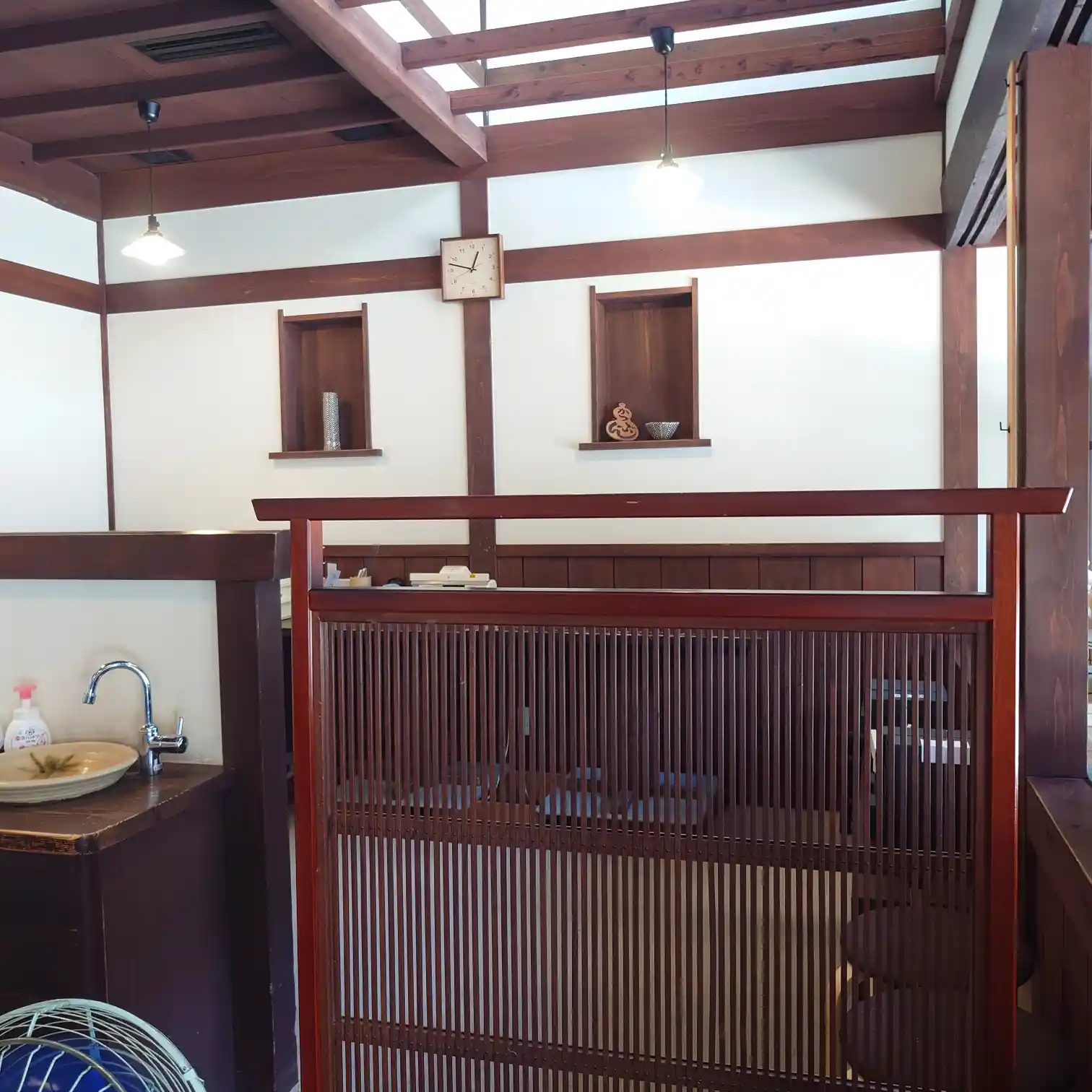 格子越しの店内風景。光と影がゆっくり揺れる。