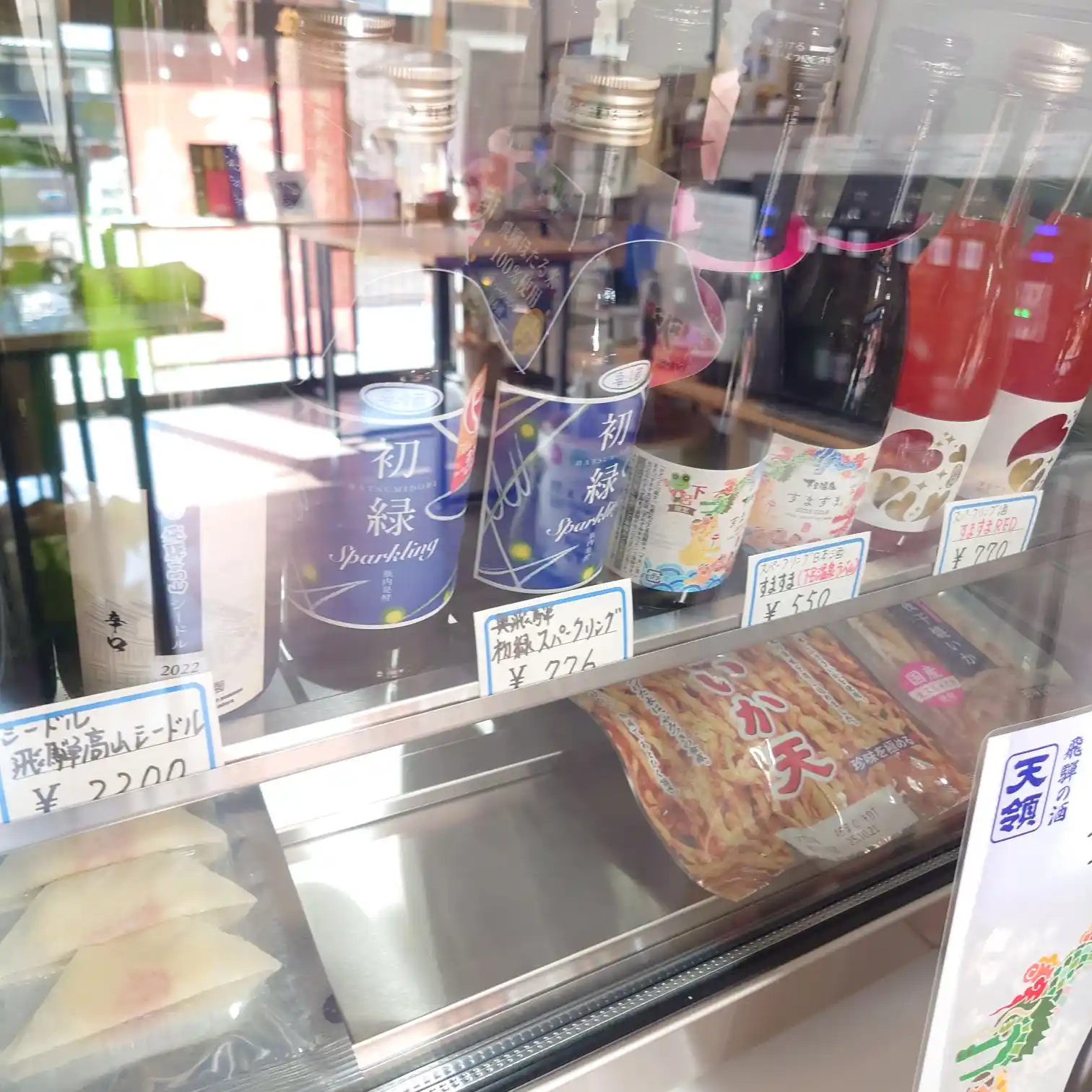 初緑スパークリングや果実酒、いか天など地元商品が並ぶ冷蔵ケース。