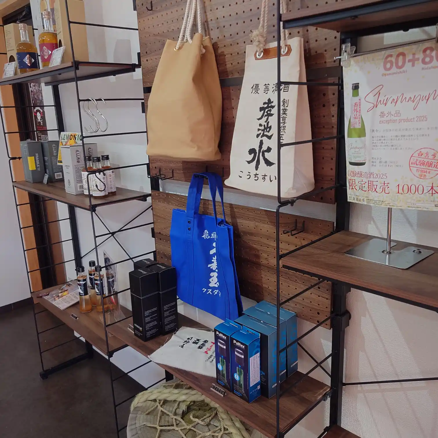 店内のグッズ棚。酒瓶用トートやエコバッグ、ギフト用商品が並ぶ。