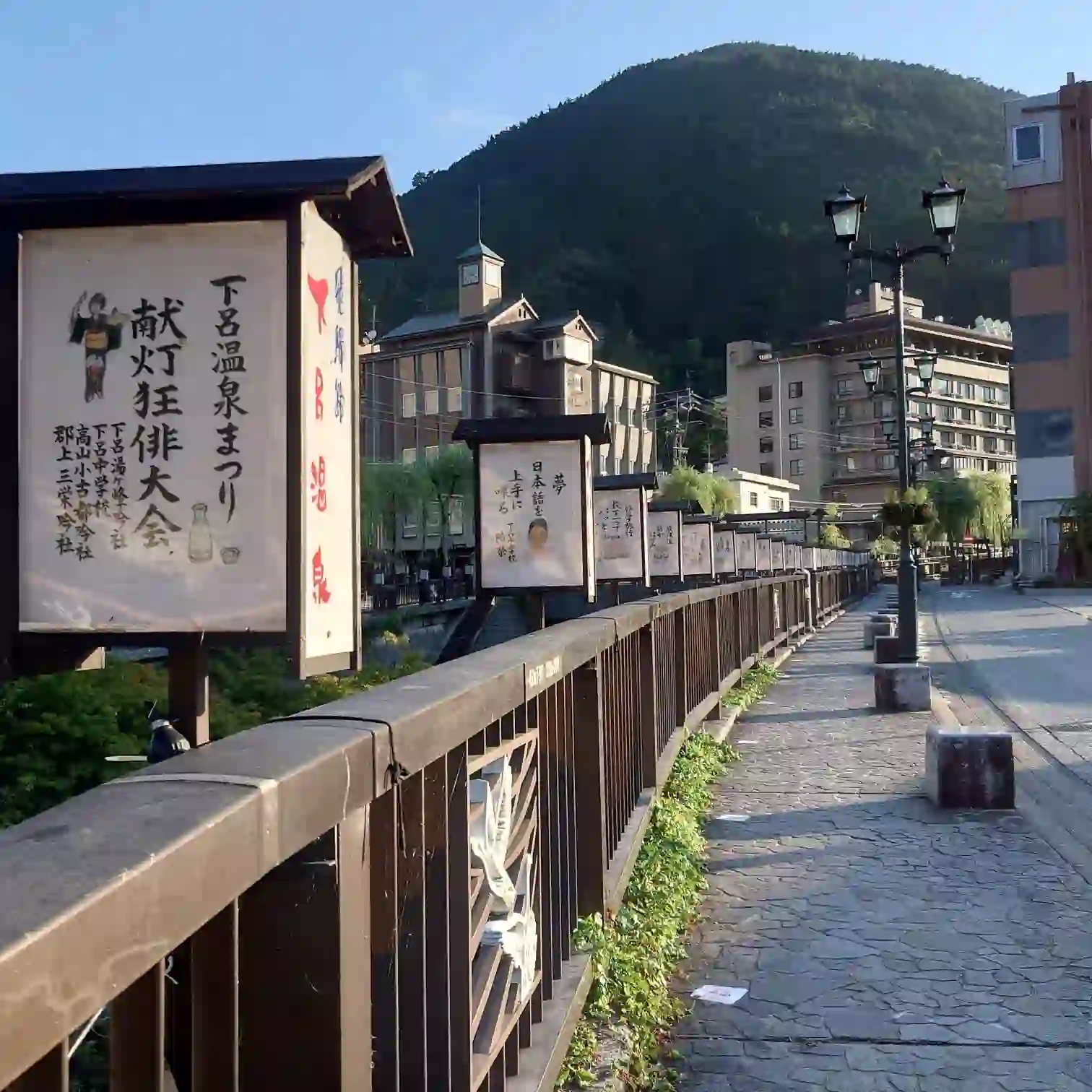 阿多野川沿いに献灯が並ぶ遊歩道。下呂温泉まつりの行灯を眺めつつ、飛騨川へ続く橋を渡る朝ランの景色—菊半旅館発3kmコース