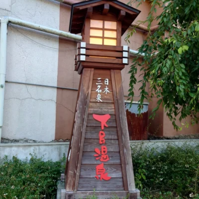 日本三名泉・下呂温泉の木製灯籠モニュメント、灯りに赤い「下呂温泉」の文字が映える阿多野川沿いの撮影スポット—菊半旅館発3kmコース