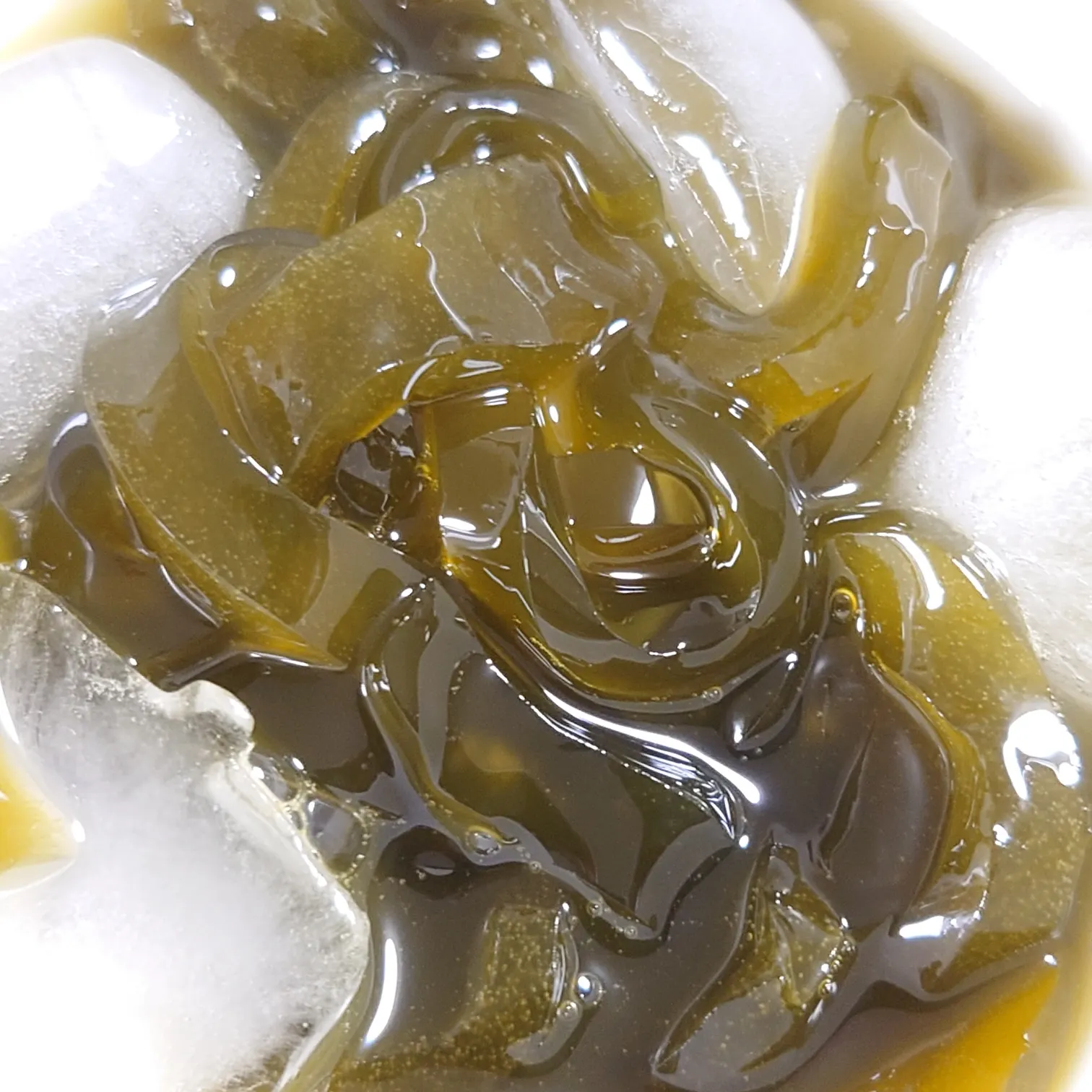 氷とともに器に盛られた抹茶くずきりのアップ。つるりと艶やか。