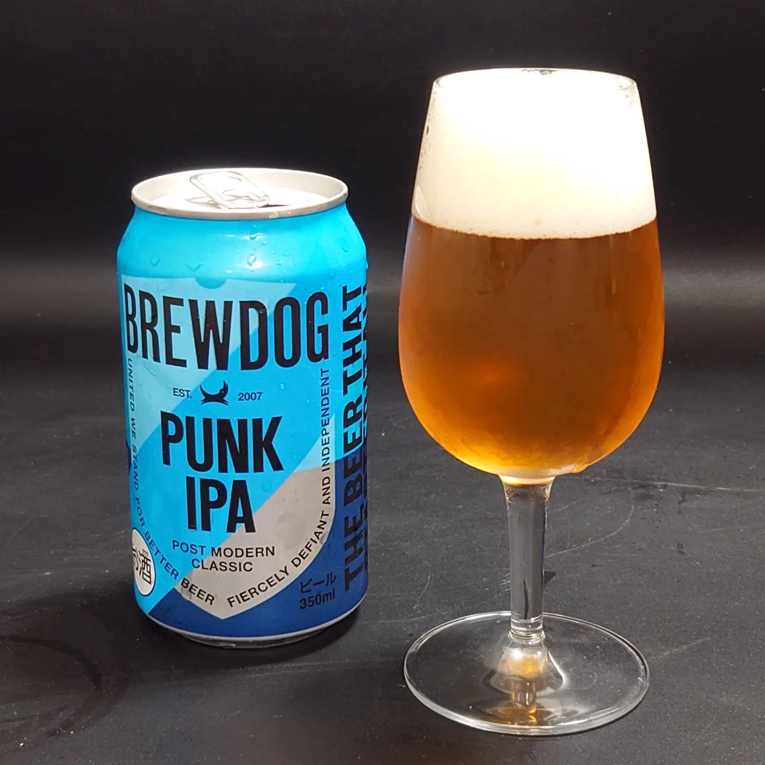 BrewDog PUNK IPAの青い350ml缶と注ぎたてのグラス—黄金色の液色とクリーミーな泡