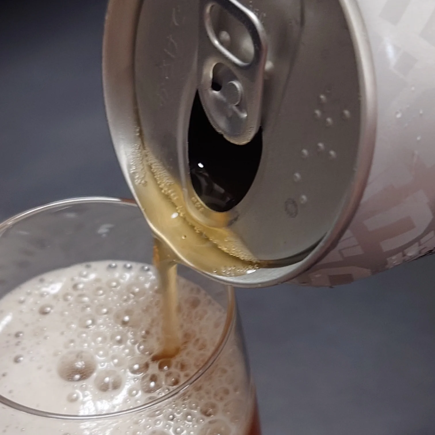 つまブル HAZYを缶からグラスへ注ぐクローズアップ。濁りある黄金色の液体ときめ細かな泡。