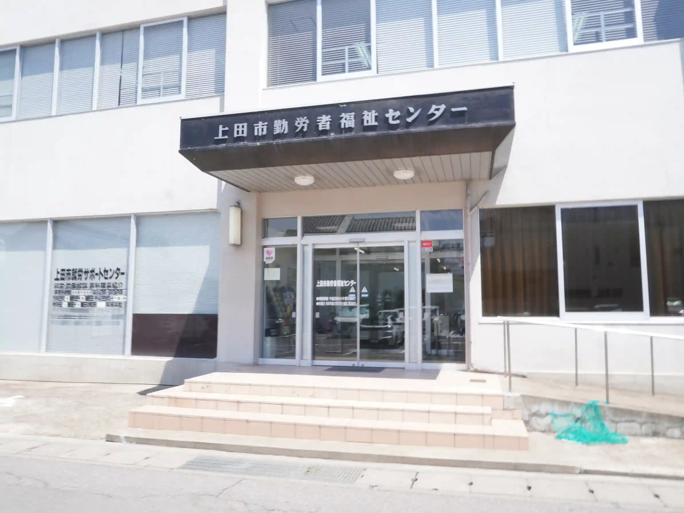 上田市勤労者福祉センターの正面入口。岡崎酒造来訪者向け駐車の目印（現在、酒蔵前は通行不可）