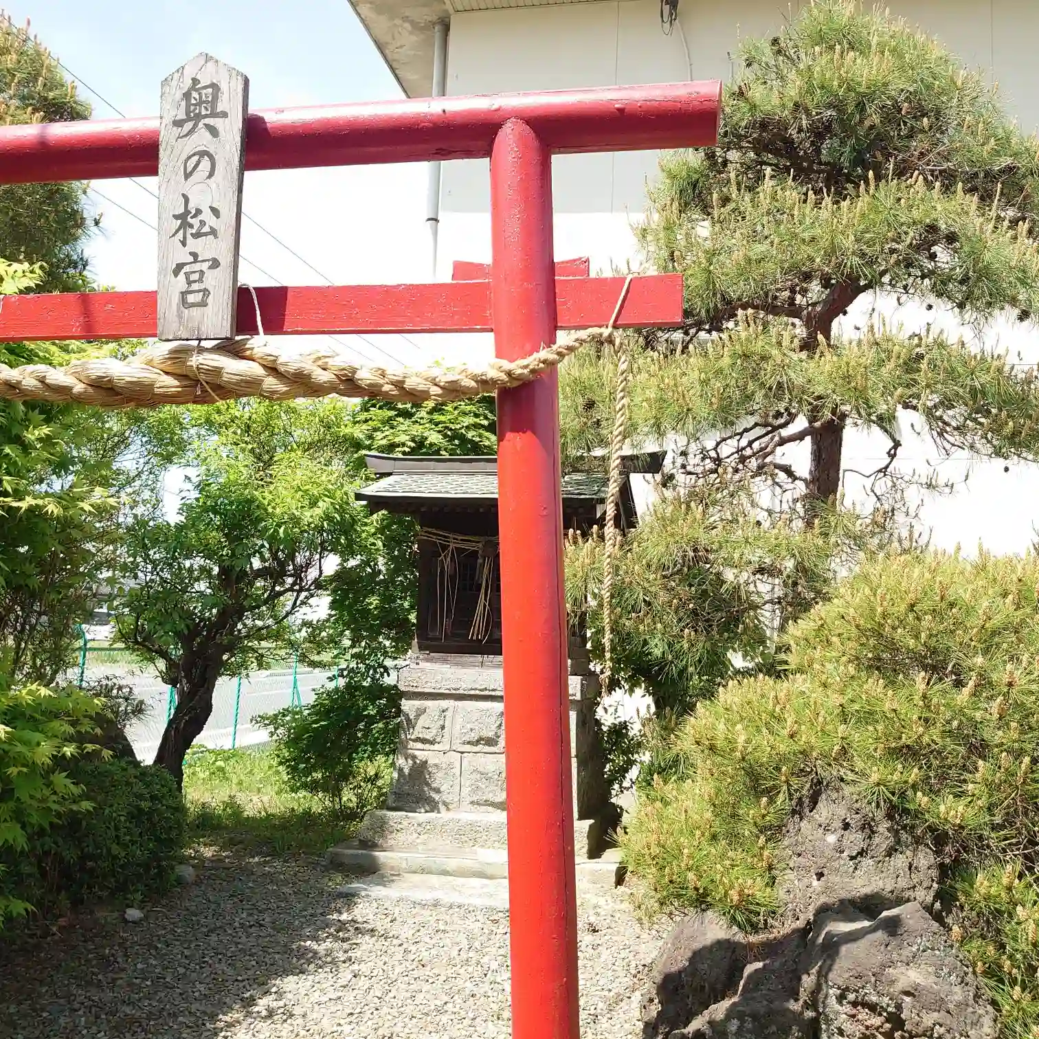 奥の松酒造の敷地内にある「奥の松宮」の赤い鳥居と小さな祠