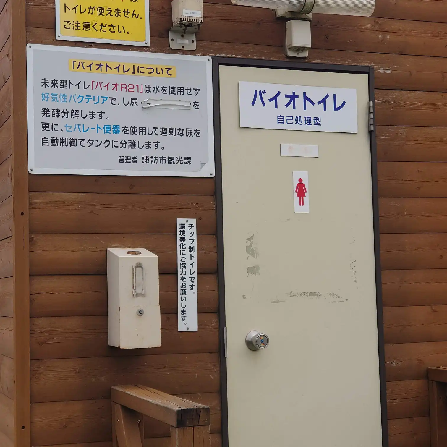 木造外観のバイオトイレ入口と注意書き