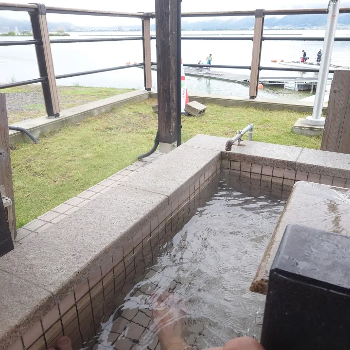 諏訪湖畔の足湯で疲れた脚を癒やす。湖を望む湯舟