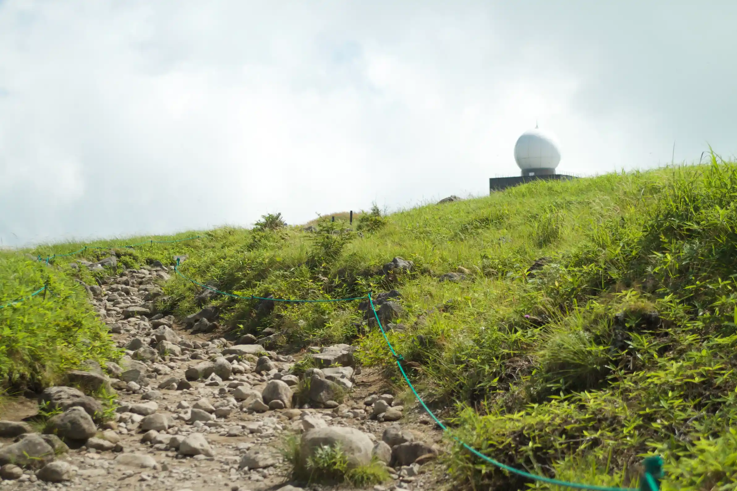 車山山頂に向かう岩混じりの登山道。遠くに白いレーダードーム