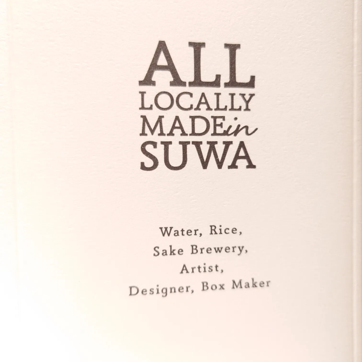長野・諏訪の日本酒「野良 Nora」—化粧箱側面の「ALL LOCALLY MADE in SUWA」ロゴとWater・Rice・Sake Brewery・Artist・Designer・Box Makerのローカル宣言