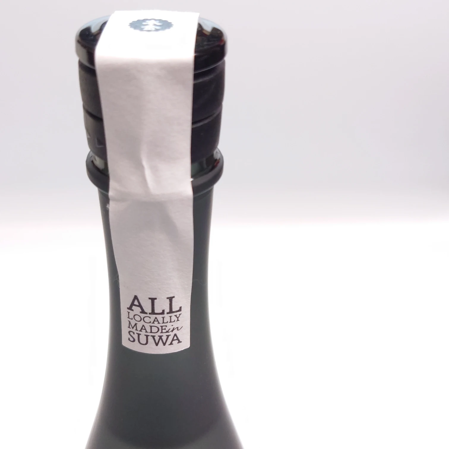 長野・諏訪の日本酒「野良 Nora」—瓶口の封紙に「ALL LOCALLY MADE in SUWA」を印字、本金ロゴ栓のクローズアップ