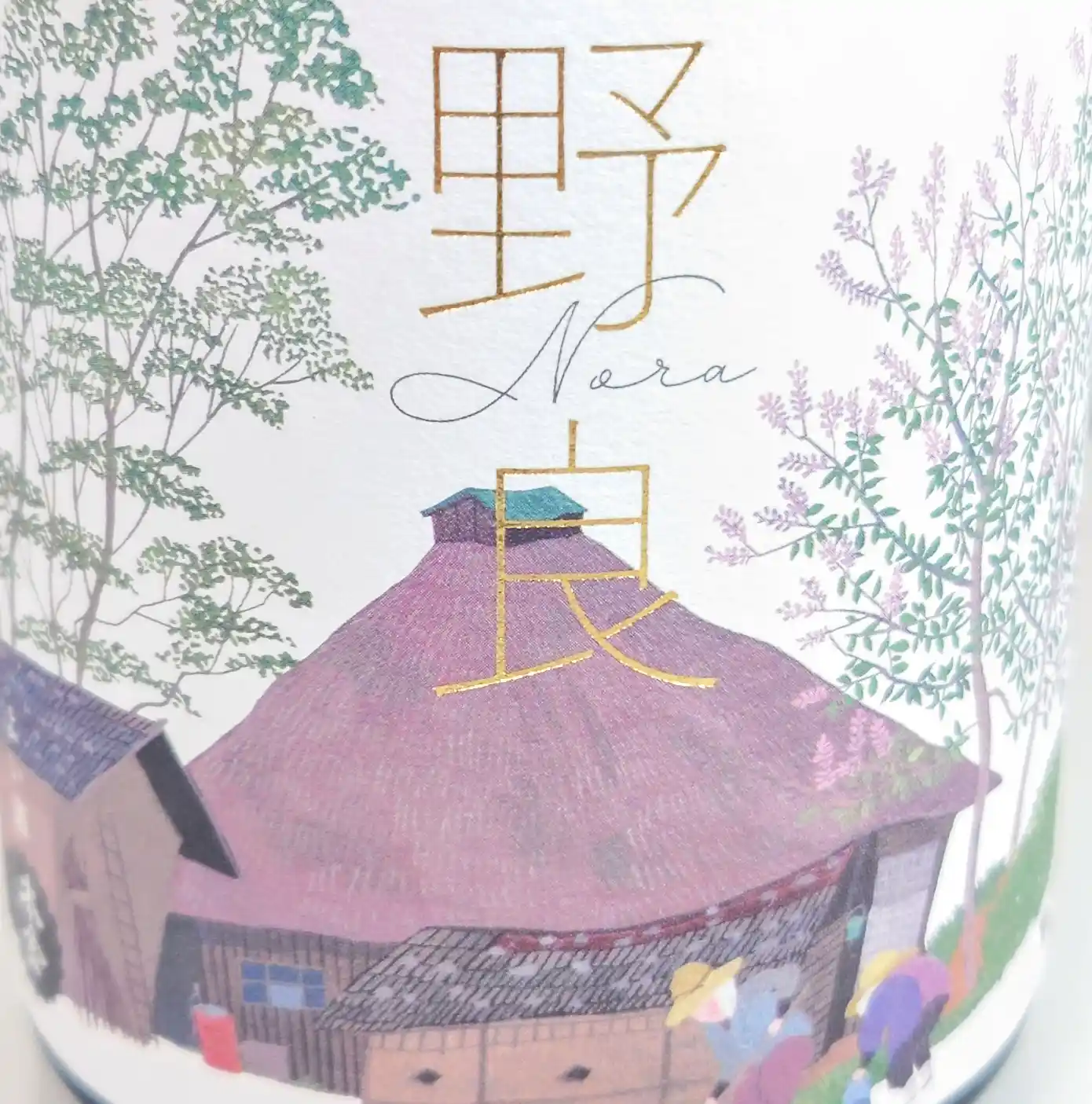 日本酒「野良 Nora」本金—原田泰治の作品「野良仕事」を配したラベル拡大、金色箔押しの文字と美しい色合いの農村風景