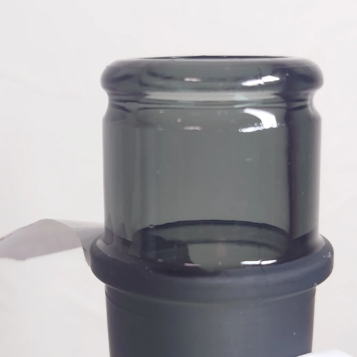 日本酒「野良 Nora」本金—一升瓶用の黒栓を外した後の瓶口クローズアップ、ガラスの滑らかな質感と美しいフォルム