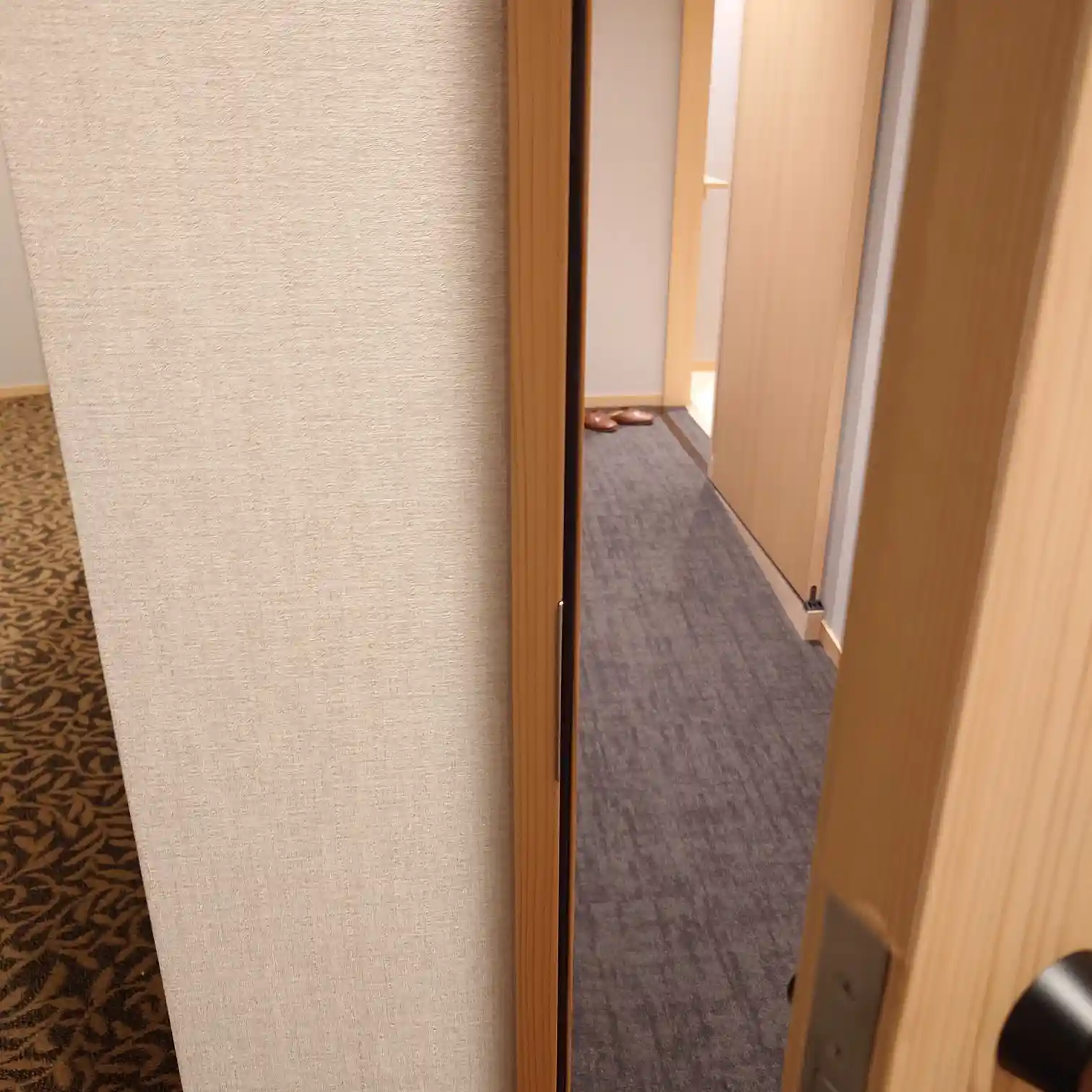 玄関から室内へのアプローチ。廊下の奥にスリッパが置かれている。