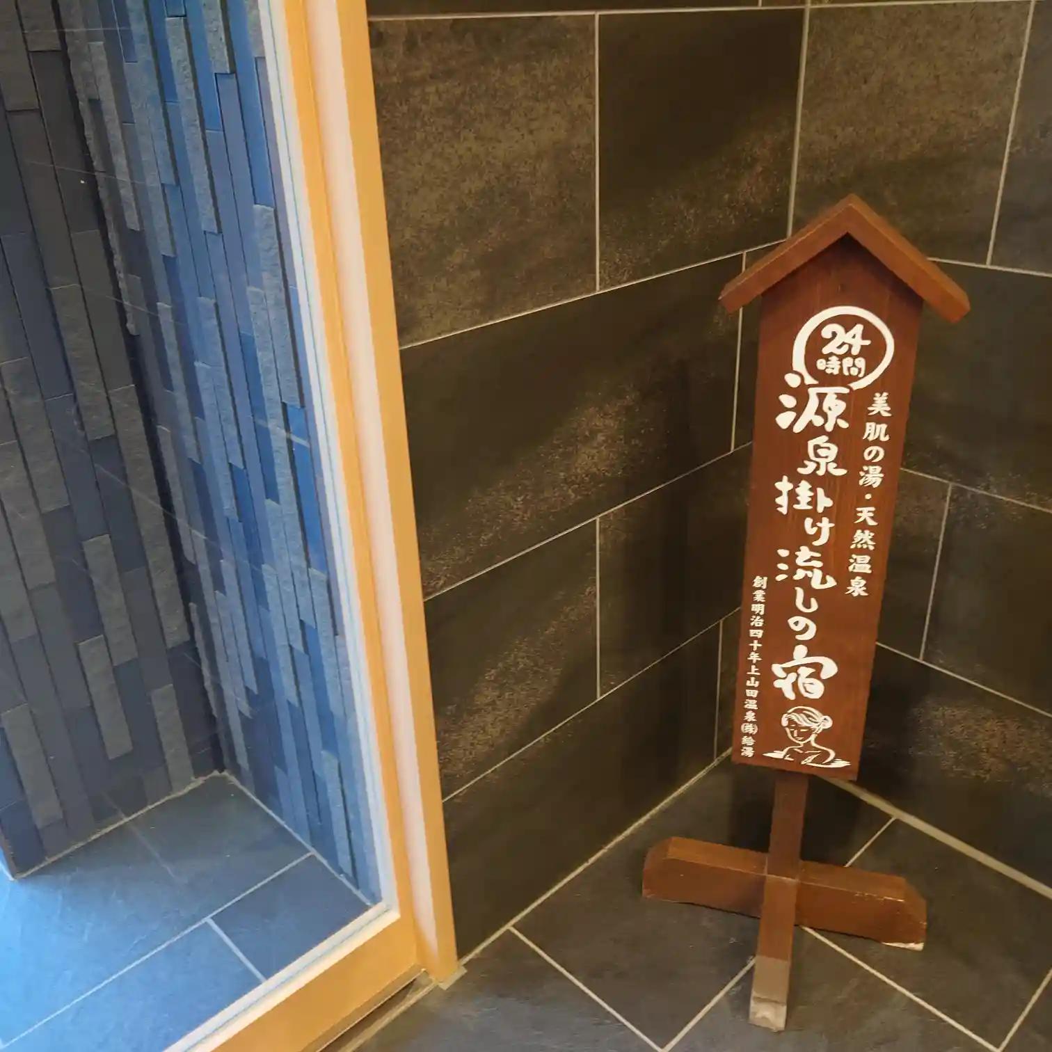 戸倉上山田温泉『ホテル晴山』の館内サイン。源泉掛け流しの宿を示す木製スタンド看板。