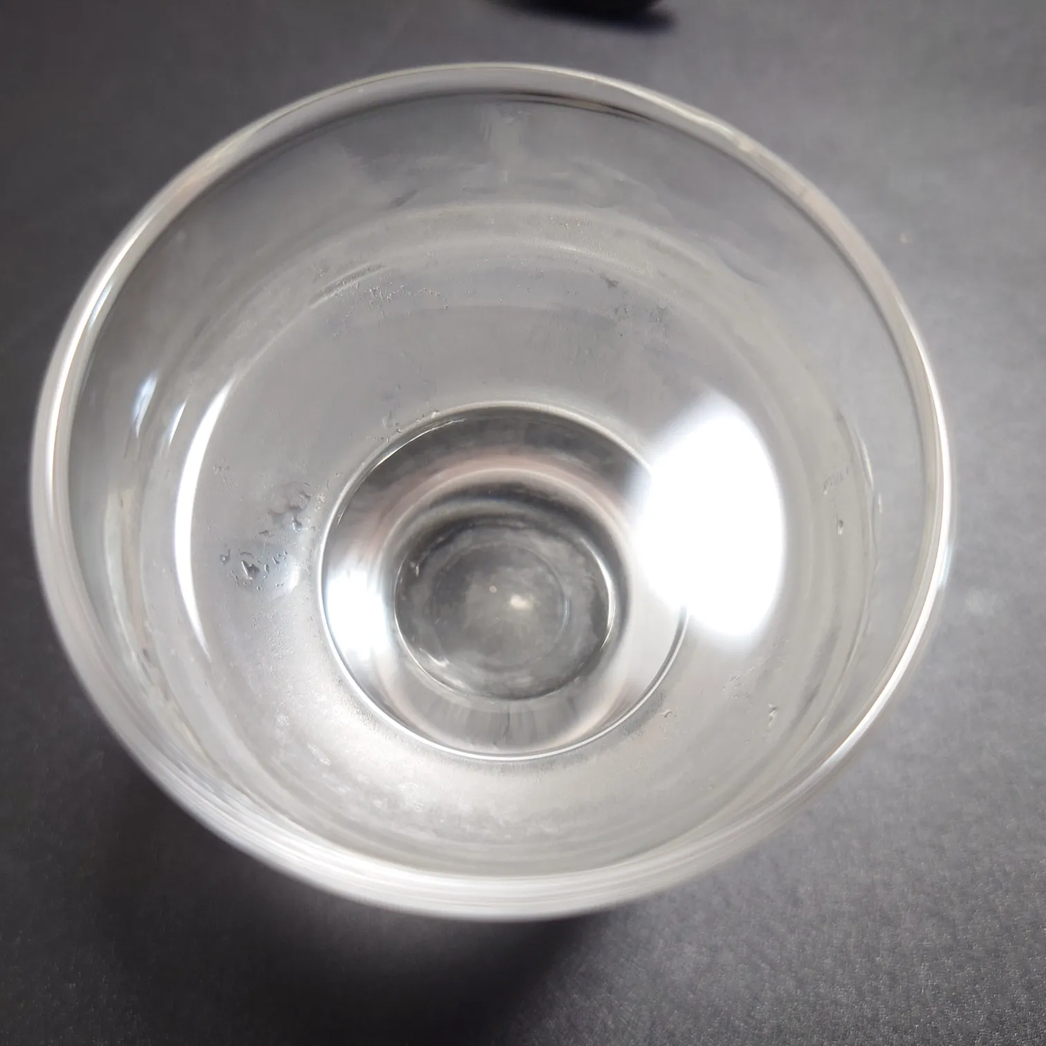 八ッ場ダム貯蔵酒|お猪口に注がれた酒の透明感を真上から撮影 八ッ場ダム貯蔵酒を注いだガラスのお猪口を真上から撮影した写真、透明感のある酒液の輝きが際立つ