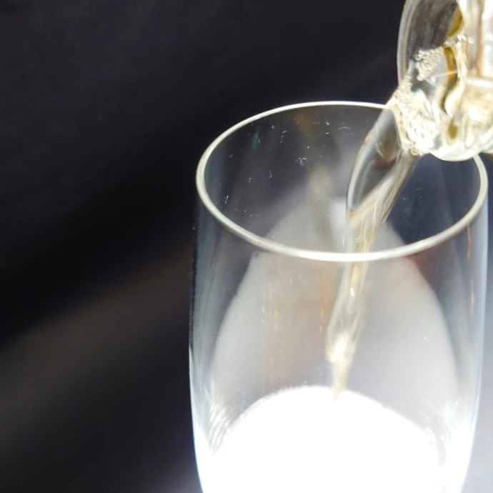 HELIOS NATURE スパークリングワインをグラスに注ぐ瞬間 グラスに注がれるスパークリングワイン「HELIOS NATURE」と立ち上がる泡の様子