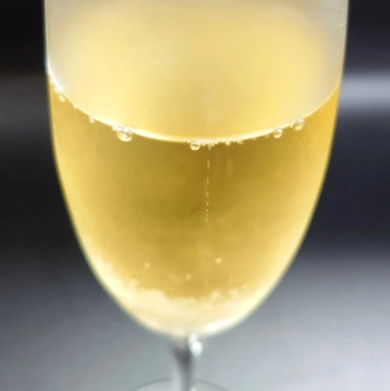 HELIOS NATURE スパークリングワインの外観と泡立ち グラスに注がれたスパークリングワイン「HELIOS NATURE」の黄金色と立ち上る泡