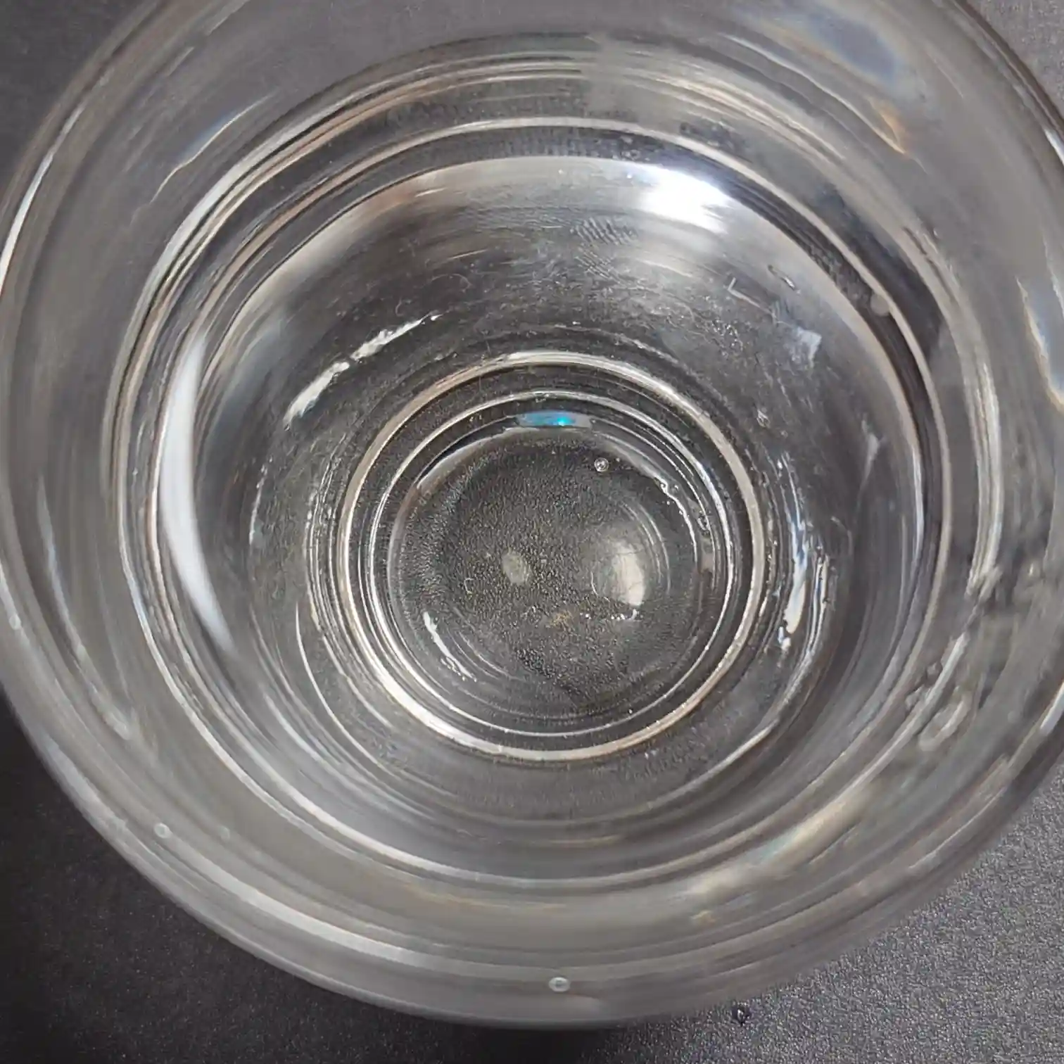 七笑 純米吟醸生酒を注いだグラスを真上から撮影したショット 無色透明の液面に小さな気泡が浮かび 日本酒の澄んだ清らかさが際立つ