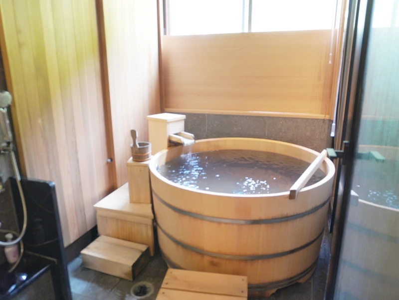 檜香る丸型半露天風呂に満たされた温泉。