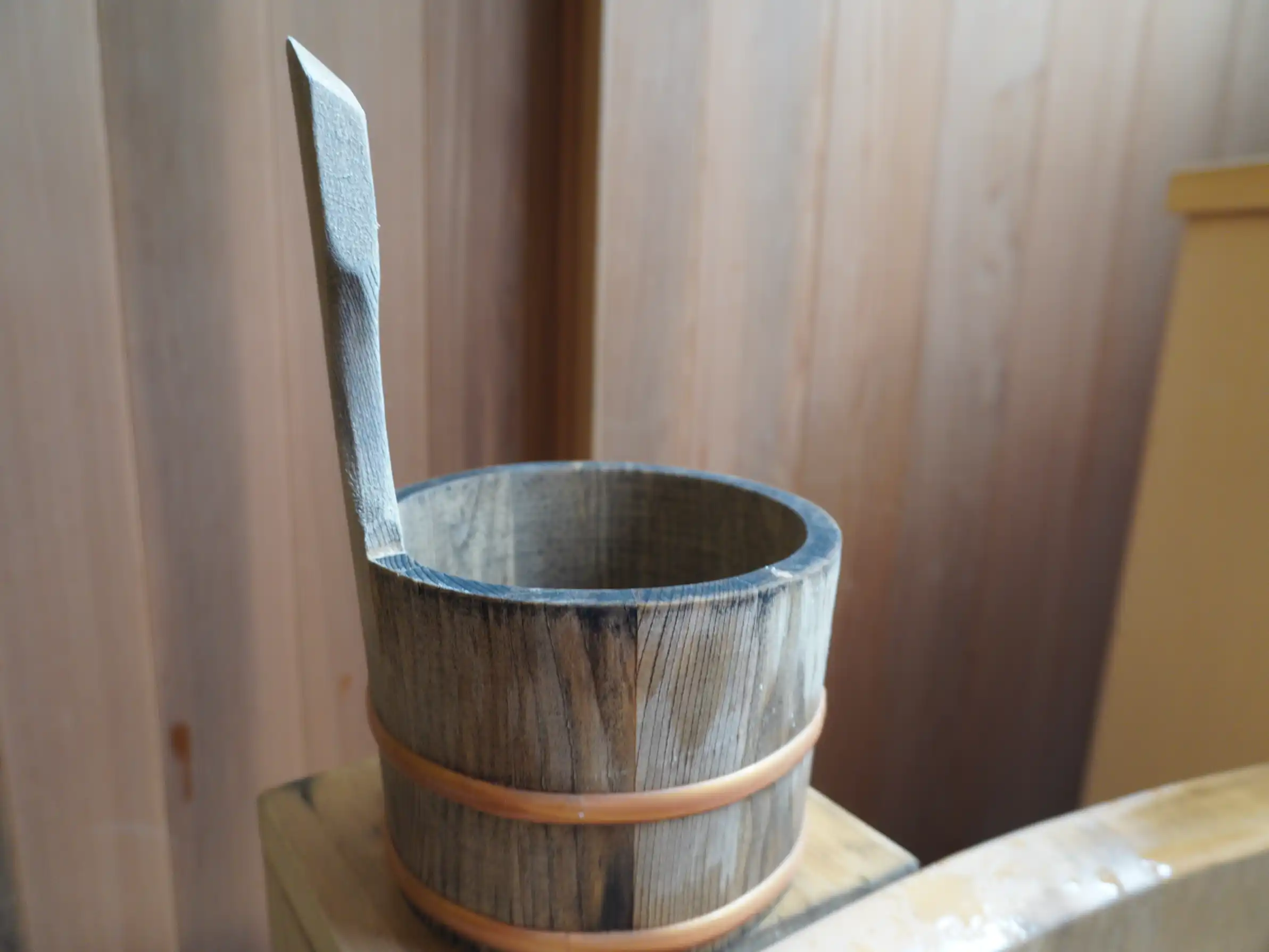 半露天に備えられた木製の湯桶と柄杓。
