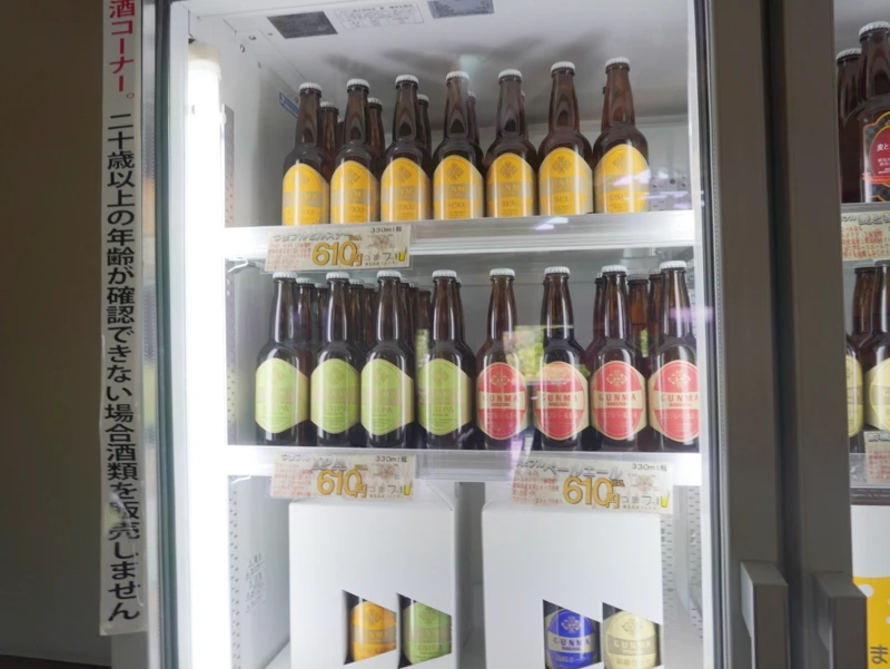 冷蔵庫に並ぶ色とりどりのつまブル瓶ビール 嬬恋高原ブルワリーの冷蔵ケース、黄色・緑・赤ラベルの瓶ビールが整然と並ぶ様子