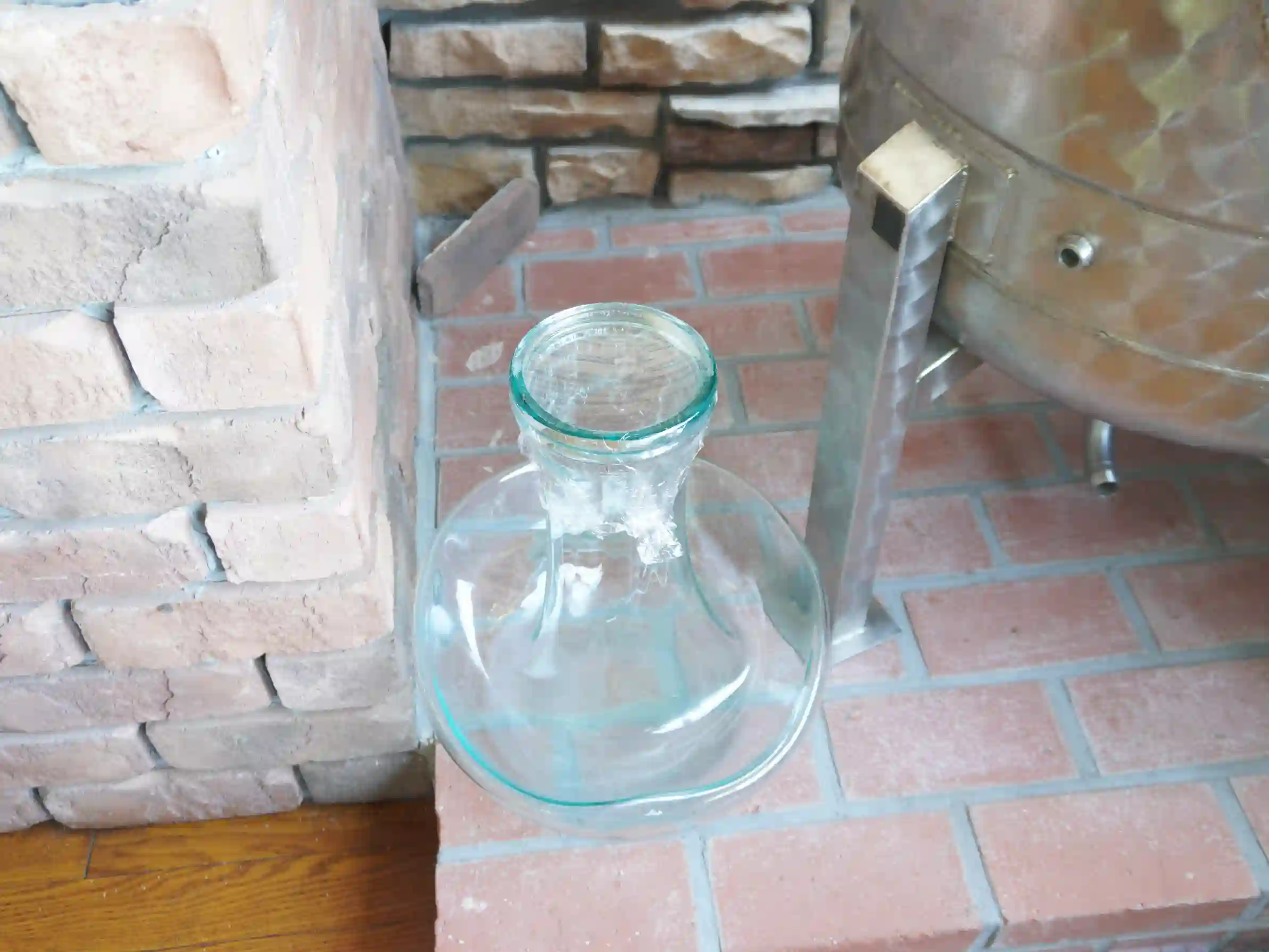 レンガ床に置かれたガラスの小瓶(嬬恋高原ブルワリー) 赤レンガ床とガラスの小瓶(デキャンタ)