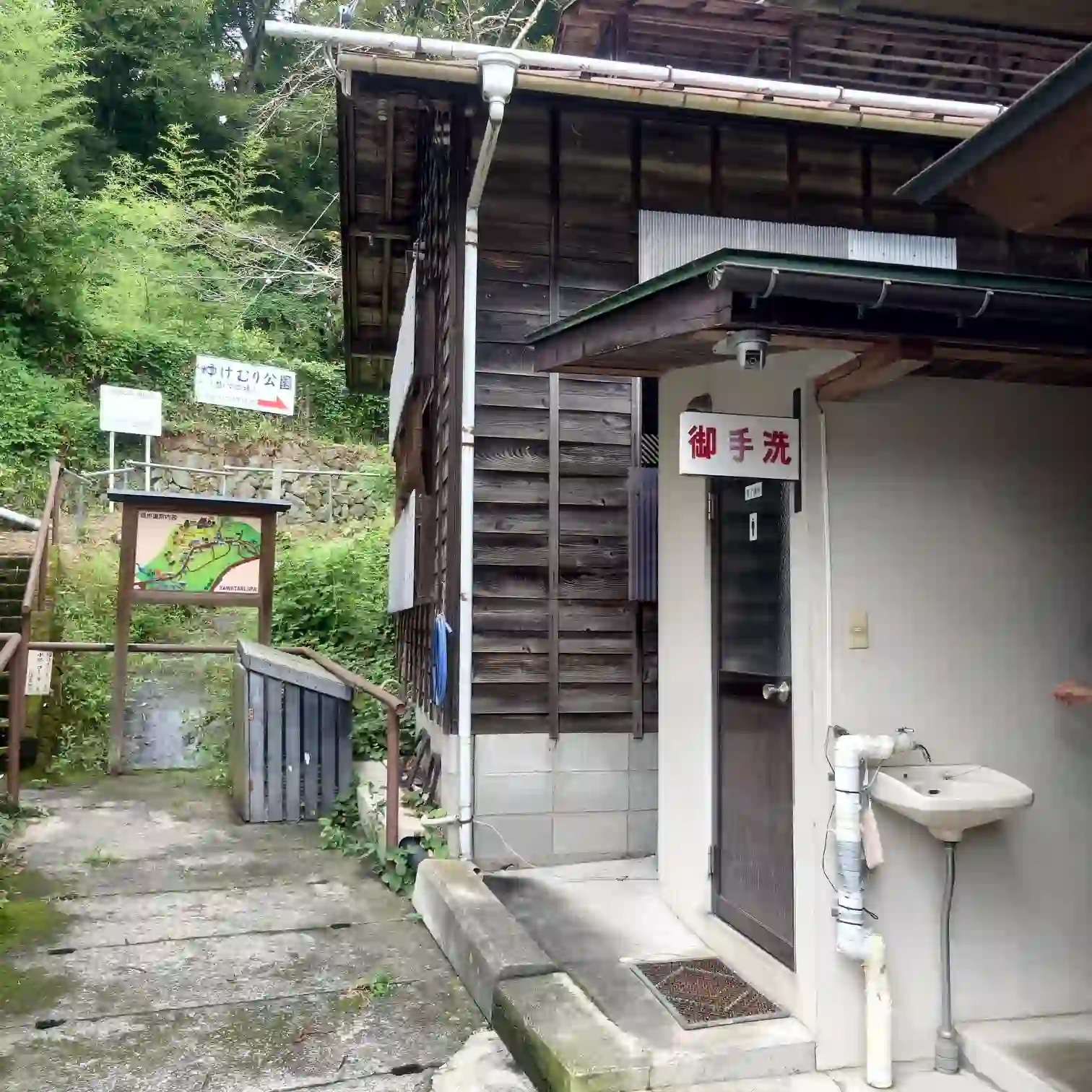 沢渡温泉共同浴場そばの公衆トイレ外観。木造の壁と「御手洗」の看板。