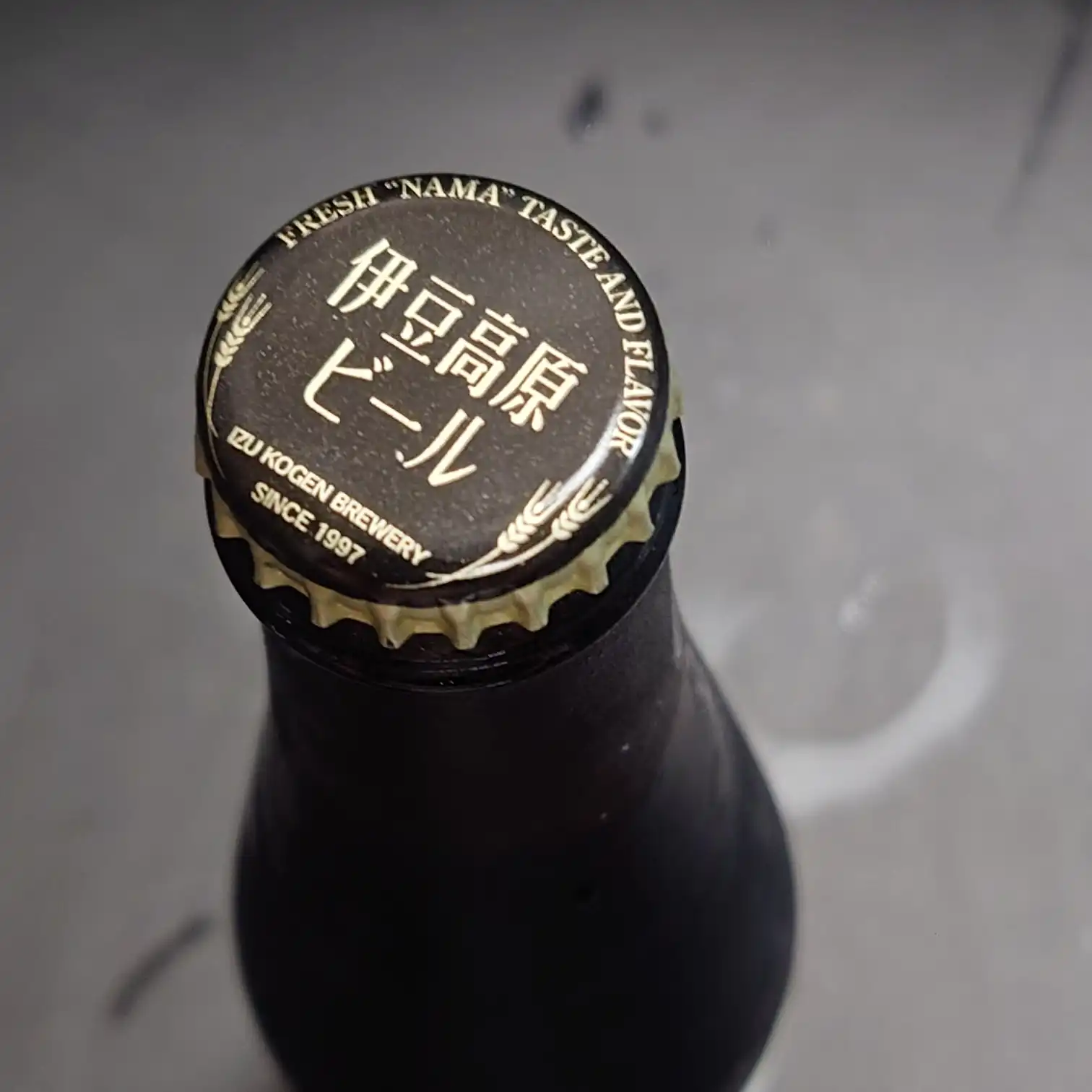 自宅で味わう伊豆高原ビール 黒スタウト(グラス&缶) 自宅テーブルで楽しむ伊豆高原ビール 黒スタウト グラスは濃いこげ茶の液色にきめ細かなベージュ泡