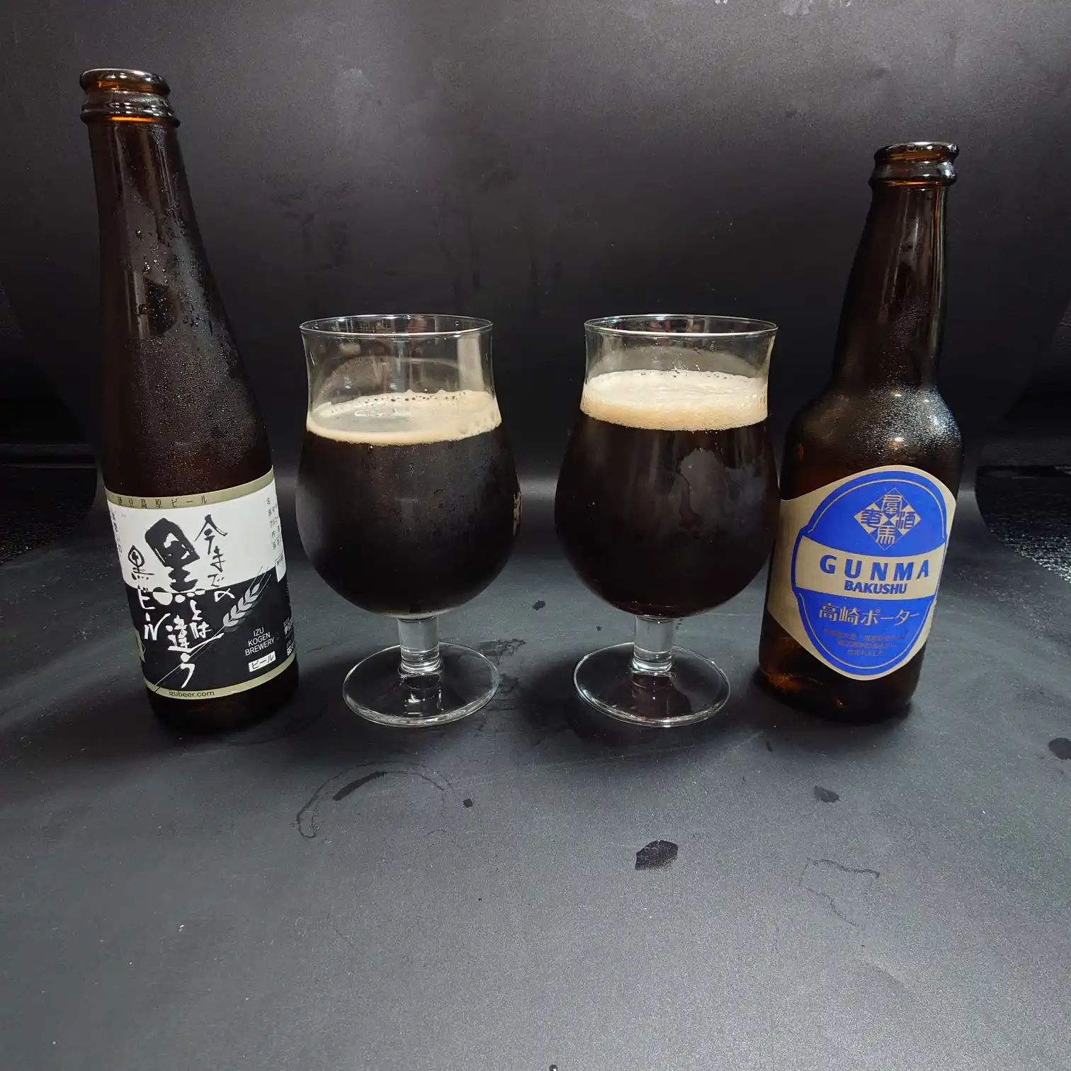 飲み比べ|2本を並べたショット(自宅撮影) 2種類の黒系ビールを自宅で並べて撮影 つまブル高崎ポーターともう1本の黒を比較 テーブル上のツーショット