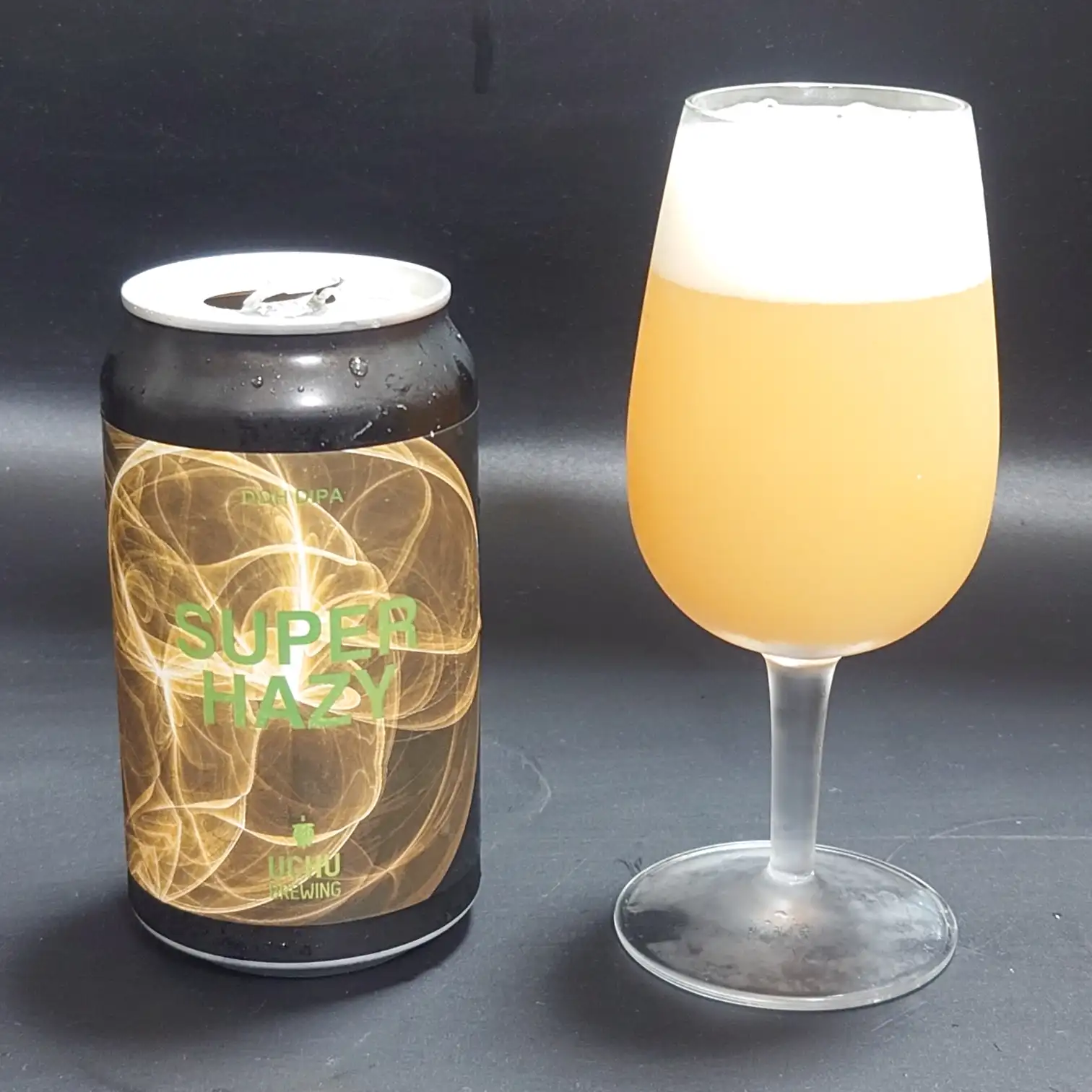 宇宙ブルーイング SUPER HAZY|缶とグラスの並びショット 宇宙ブルーイング「SUPER HAZY」缶と注ぎたてのグラスを並べた構図、黄金色の濁りと白い泡が映える