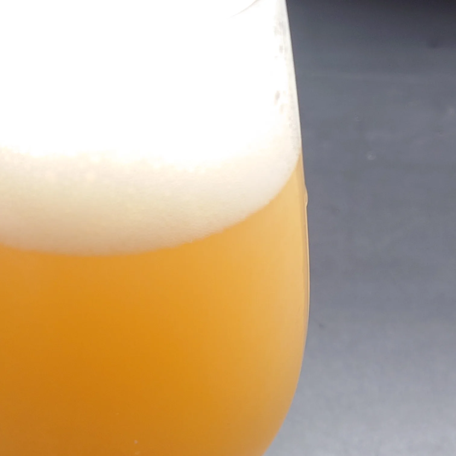 宇宙ブルーイング SUPER HAZY|濁りオレンジとふんわり泡の接写 宇宙ブルーイング「SUPER HAZY」泡と液面の接写、濃いオレンジ色のにごりときめ細かな泡立ちが美しい