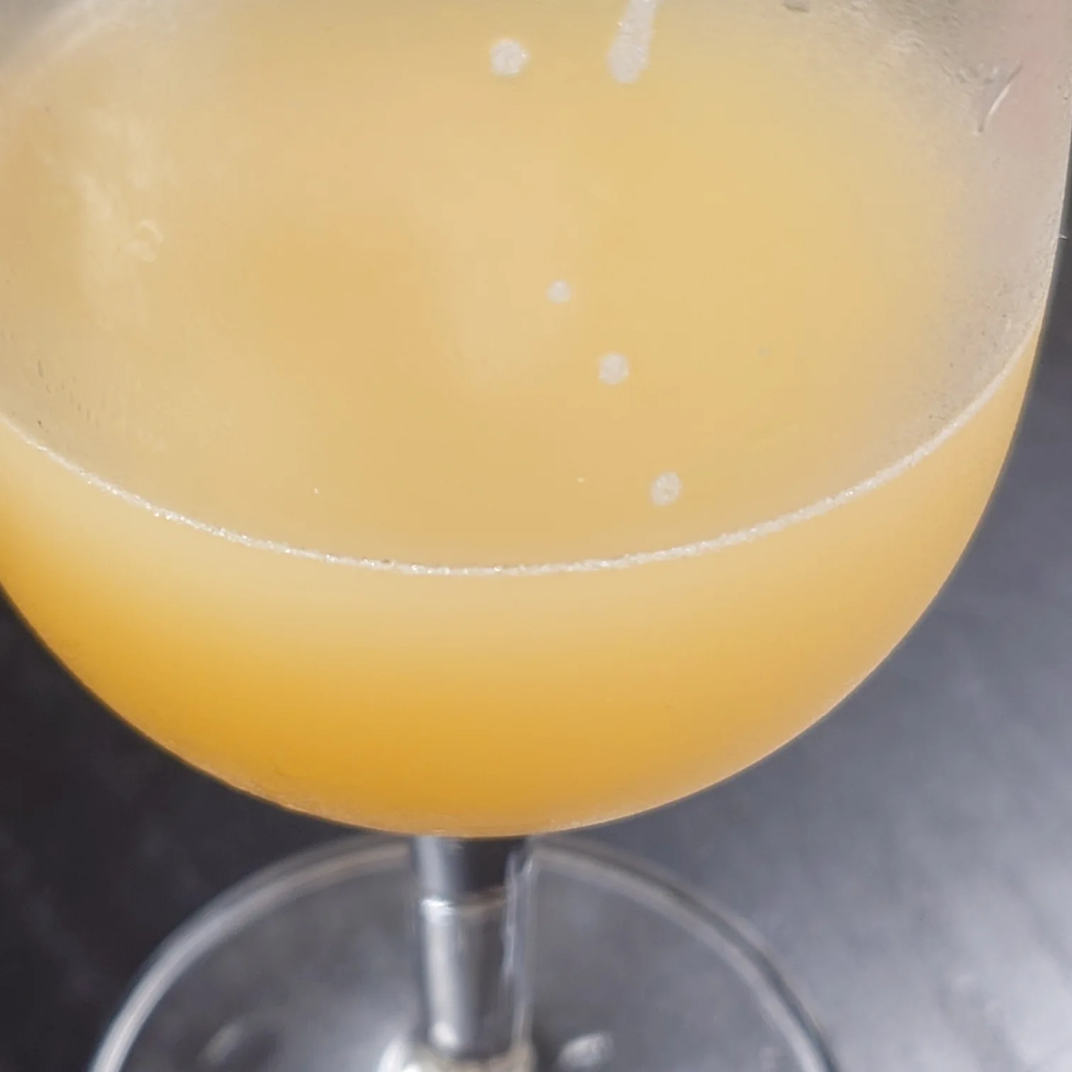宇宙ブルーイング SUPER HAZY|飲みかけでも美しいヘイジーカラーと余韻 宇宙ブルーイング「SUPER HAZY」半分ほど飲んだグラス、ヘイジーカラーが美しくマンゴーの余韻を感じる