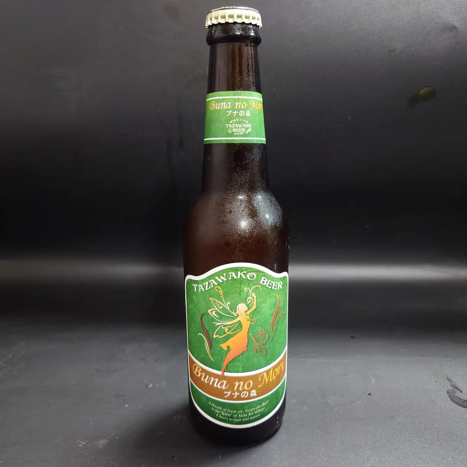 秋田 田沢湖ビール『ブナの森』のボトル正面写真。緑のラベルに妖精シルエットとBuna no Mori／ブナの森の文字