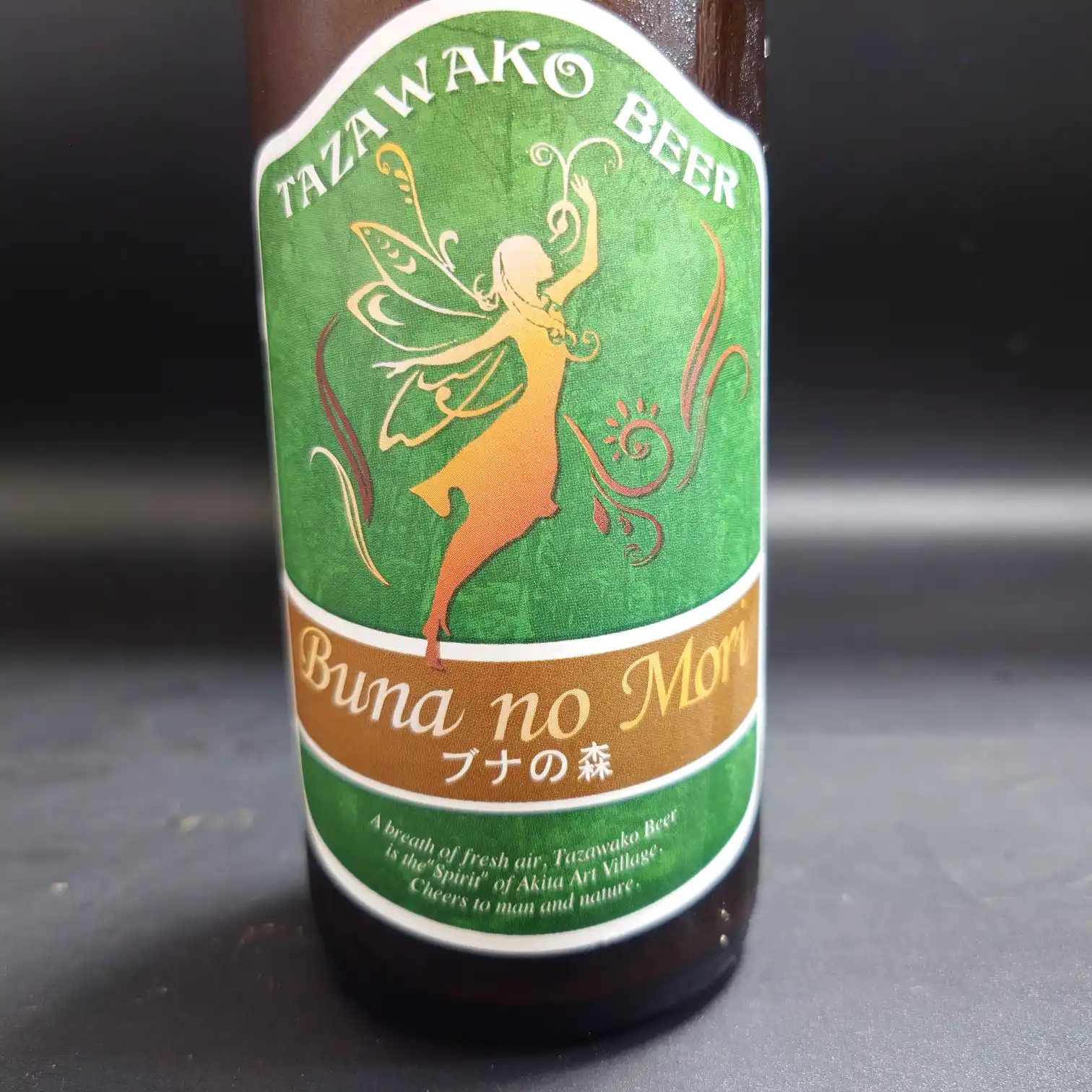 秋田 田沢湖ビール『ブナの森』のボトル正面ラベルを接写した写真。緑のラベルに妖精シルエットとBuna no Mori／ブナの森の文字が映える