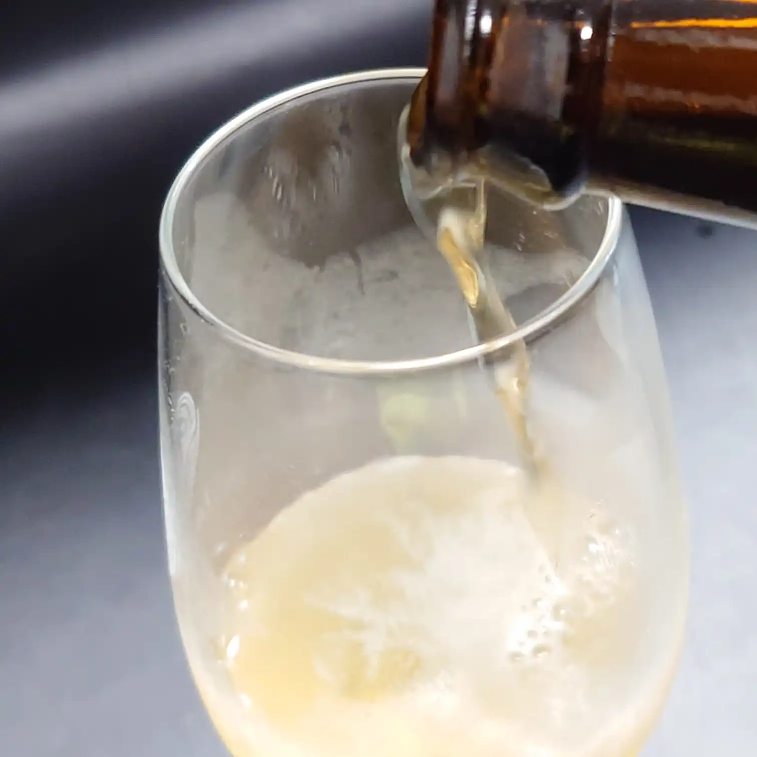 田沢湖ビール『ブナの森』をグラスに注ぐ瞬間。淡い黄金色の液体と柔らかな泡立ちが見える、フレッシュな注ぎシーン