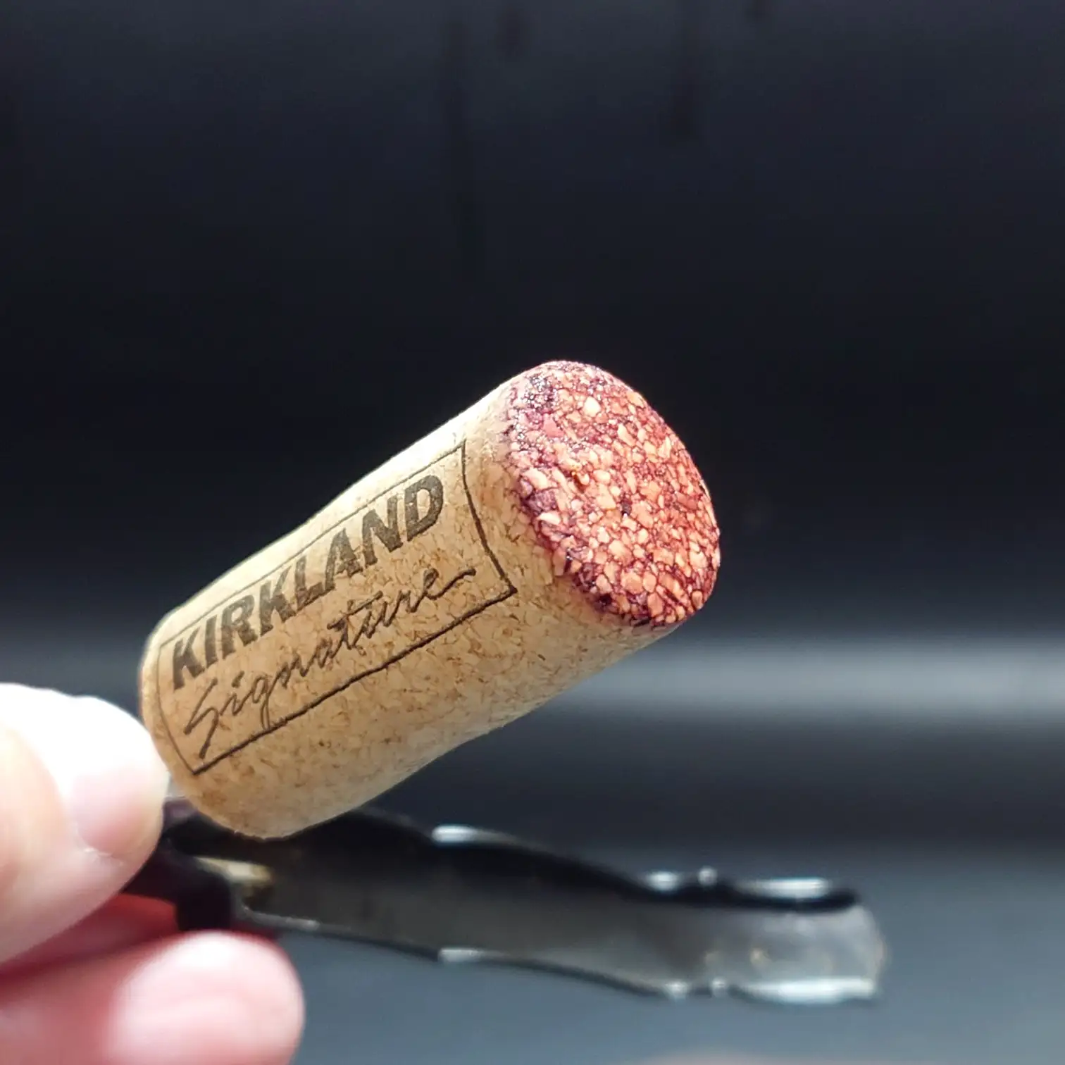 カークランド ボルドー・シュペリュール 2022 コルクロゴと染まり カークランド ボルドー・シュペリュール2022のコルクをクローズアップ。ワインの赤が染みた先端とKIRKLAND Signatureロゴが印象的に映える。