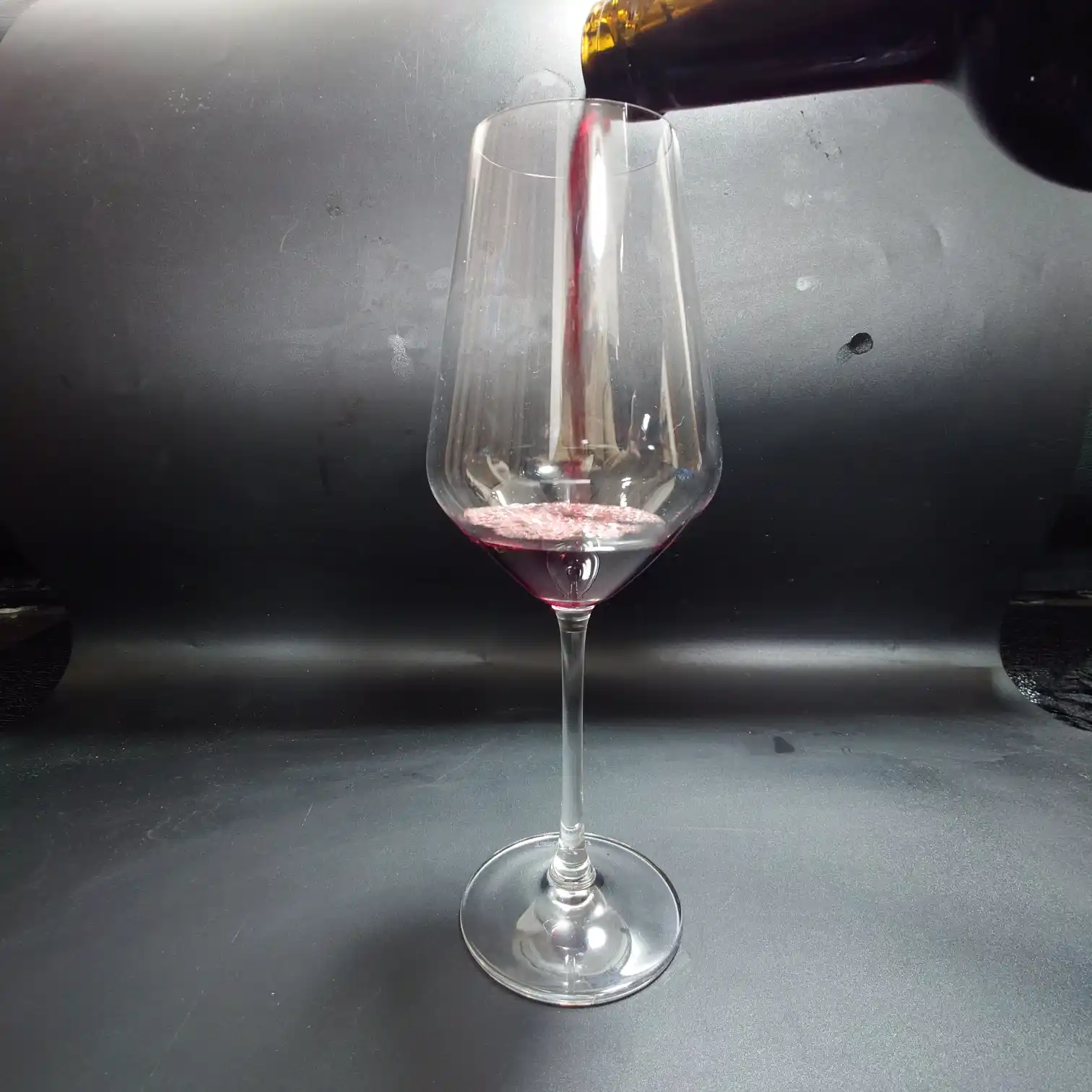 カークランド ボルドー・シュペリュール 2022 注ぐ瞬間と赤の艶 カークランド ボルドー・シュペリュール2022をワイングラスに注ぐ瞬間を捉えた写真。深いルビーレッドの液面が艶やかに広がる。