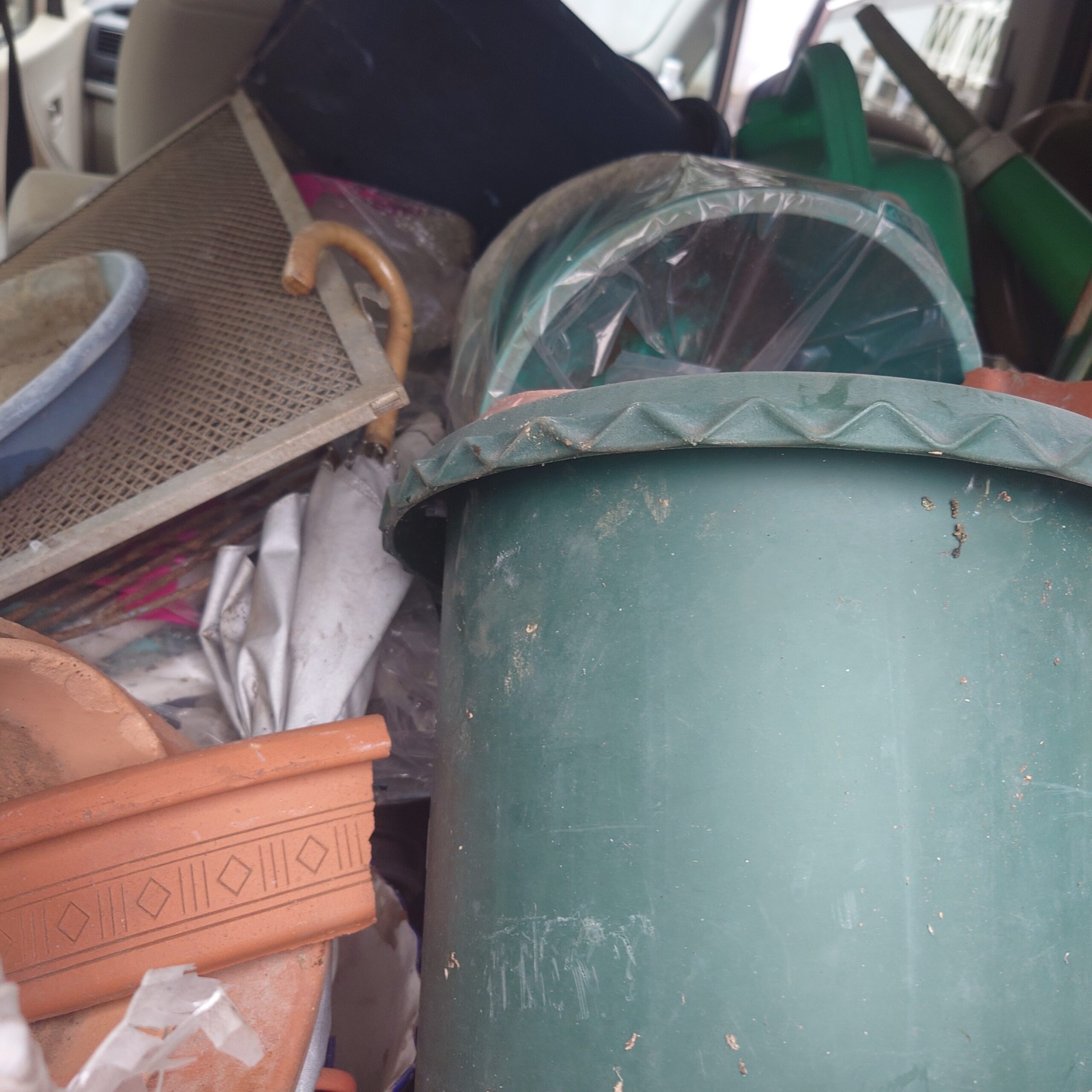 新浜リサイクルセンターへ運ぶ不燃物として、大型プラ鉢や園芸用品、古い網板などが車の荷室に積み込まれている様子。