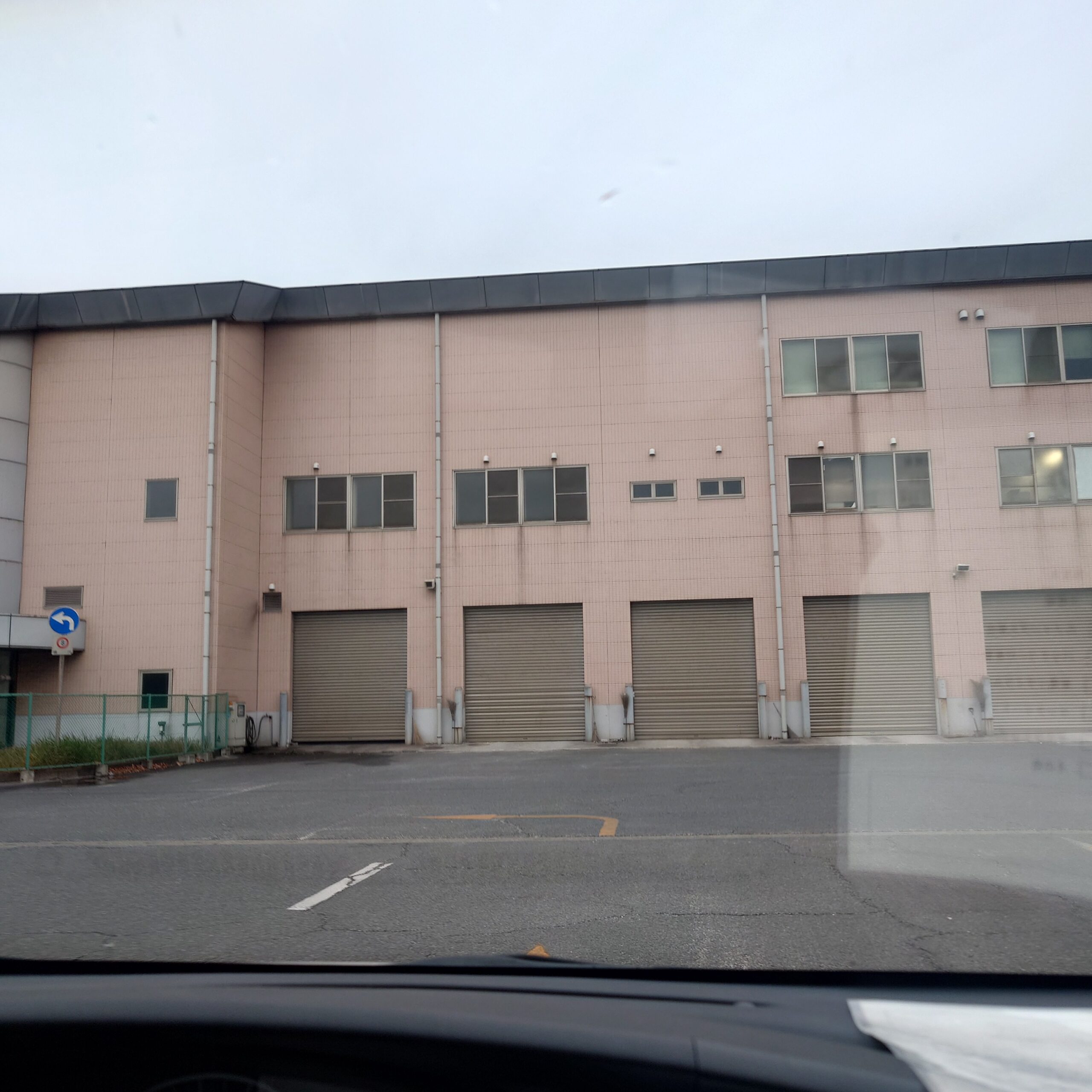 新浜リサイクルセンターの建物外観で、複数のシャッター扉が並ぶ搬入エリアを車内から撮影した様子。