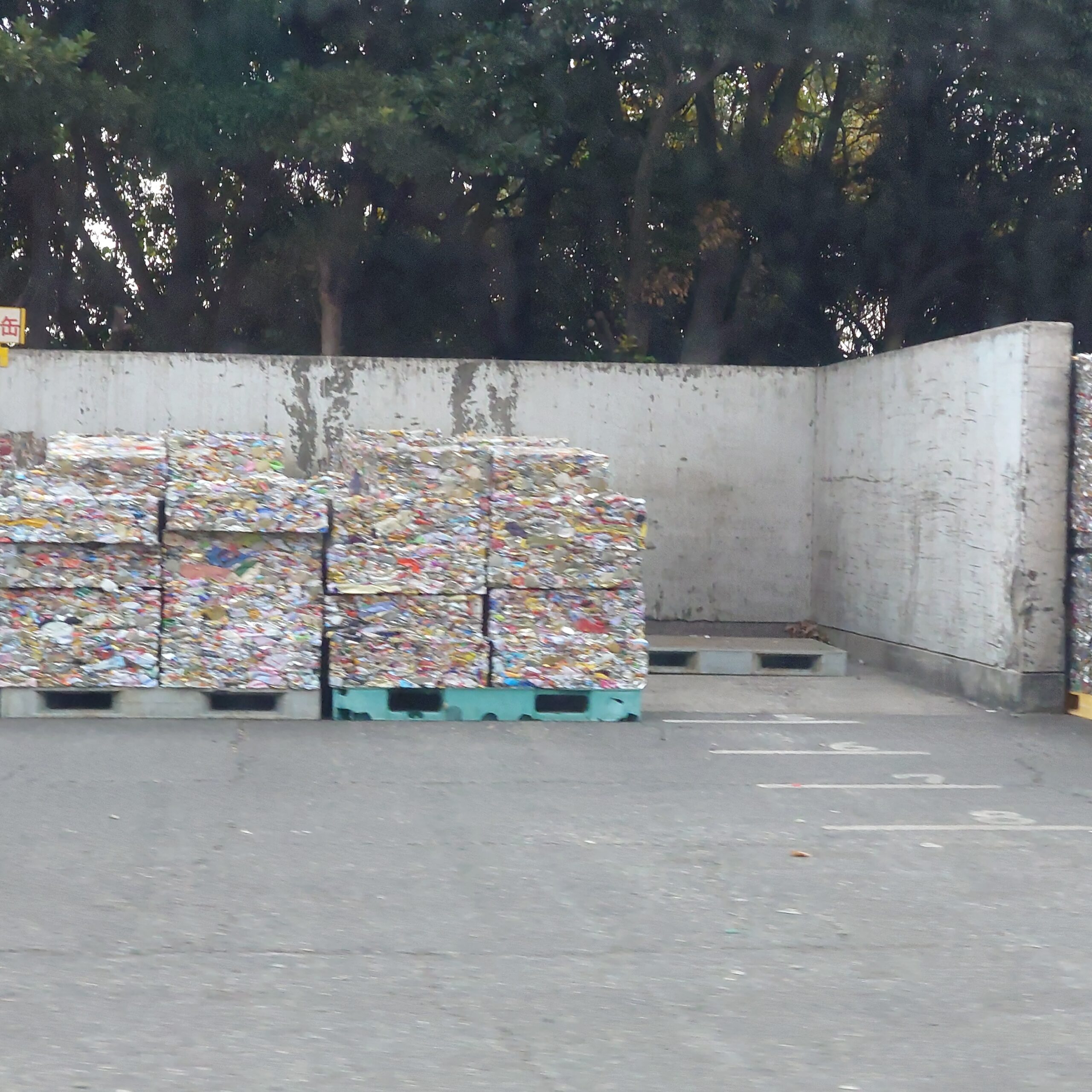 新浜リサイクルセンター構内に積み上げられた圧縮アルミ缶のブロック。リサイクル処理を待つ大量のアルミ資源が並んでいる様子。