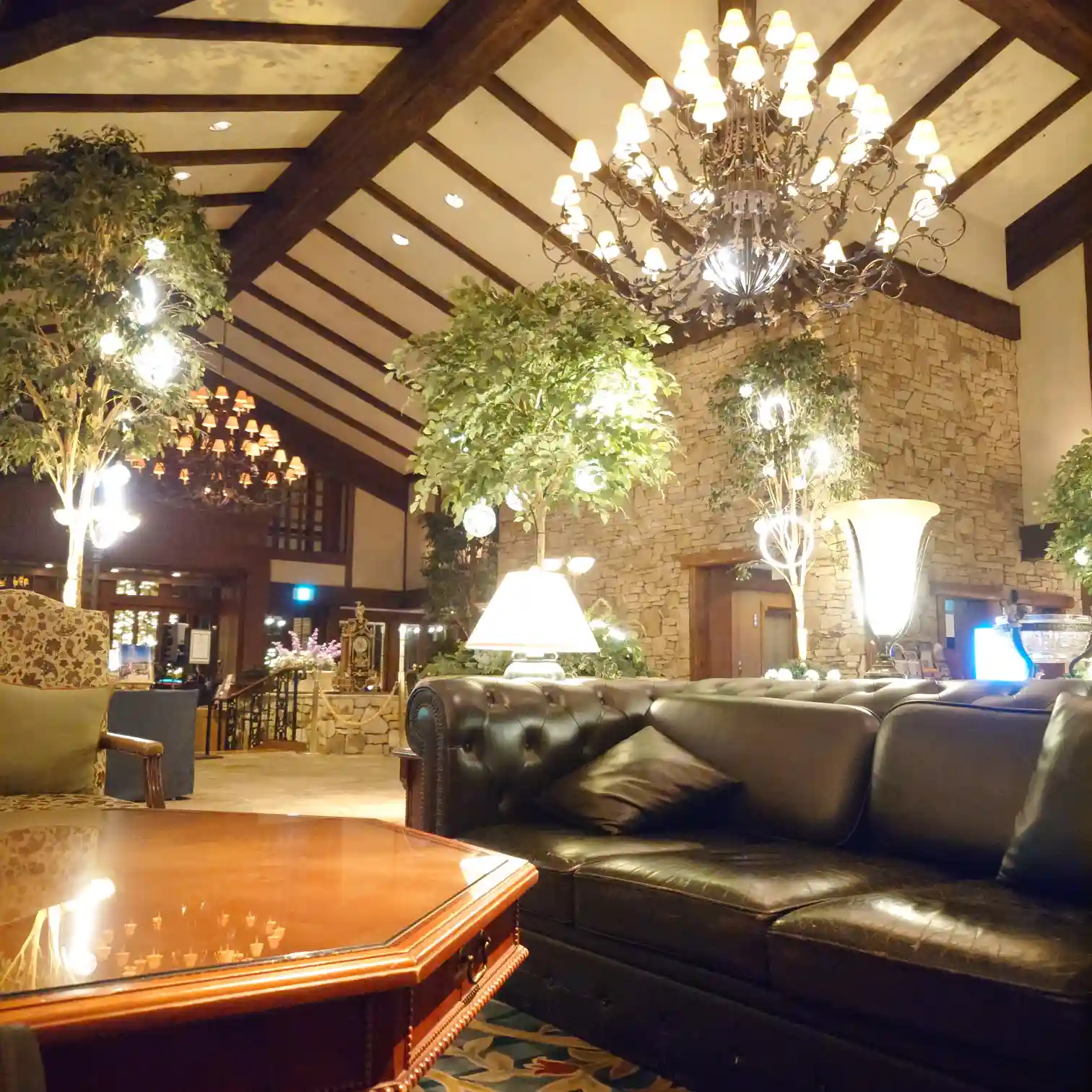 エクシブ蓼科 ロビーラウンジ近くのソファ　シャンデリアと石壁の空間で食後の余韻