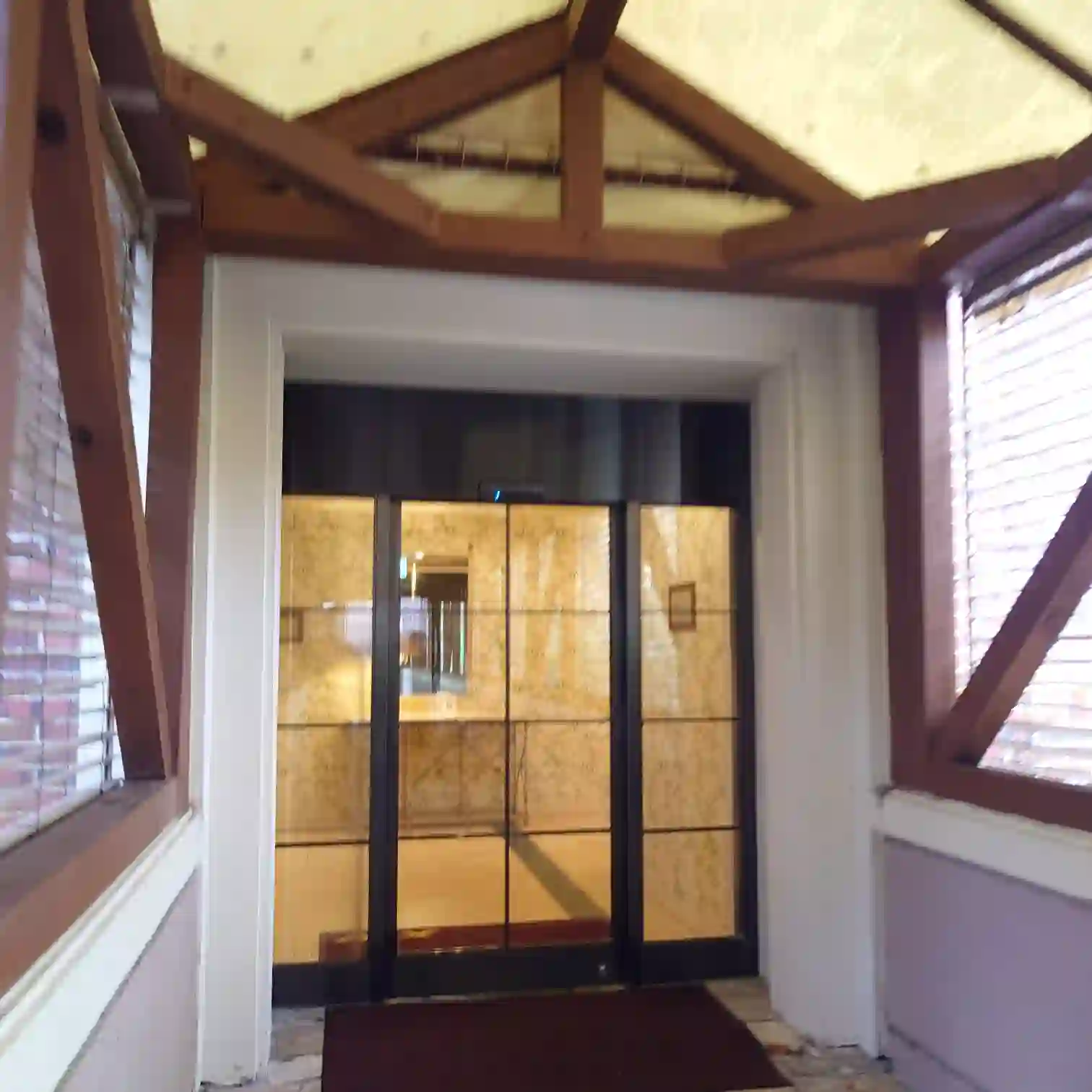 会員制ホテル エクシブ蓼科 スイート棟入口　木組みの屋根とガラス扉　朝の静けさが漂うアプローチ