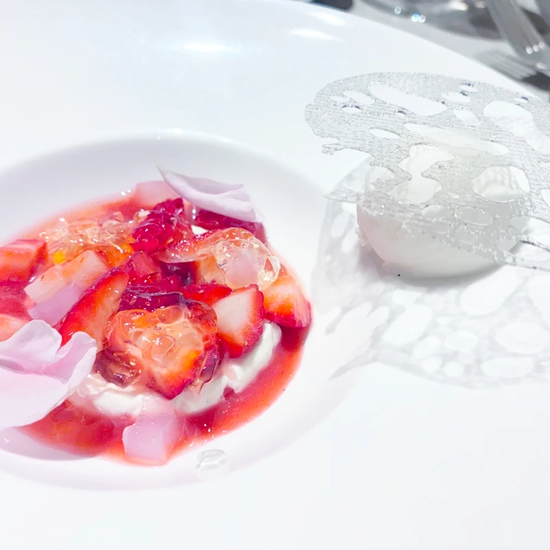 ルッチコーレのデザート　苺とホワイトチョコレートのムース（苺とジュレ、飴細工の透明プレートが浮かぶ盛り付け）