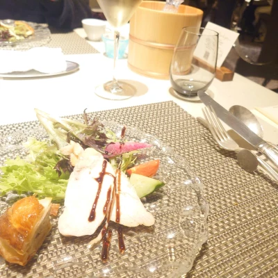 ルッチコーレのコース前菜　彩り豊かなサラダ（ガラス皿に盛られた野菜とソース、テーブル上のシャンパンと共に）